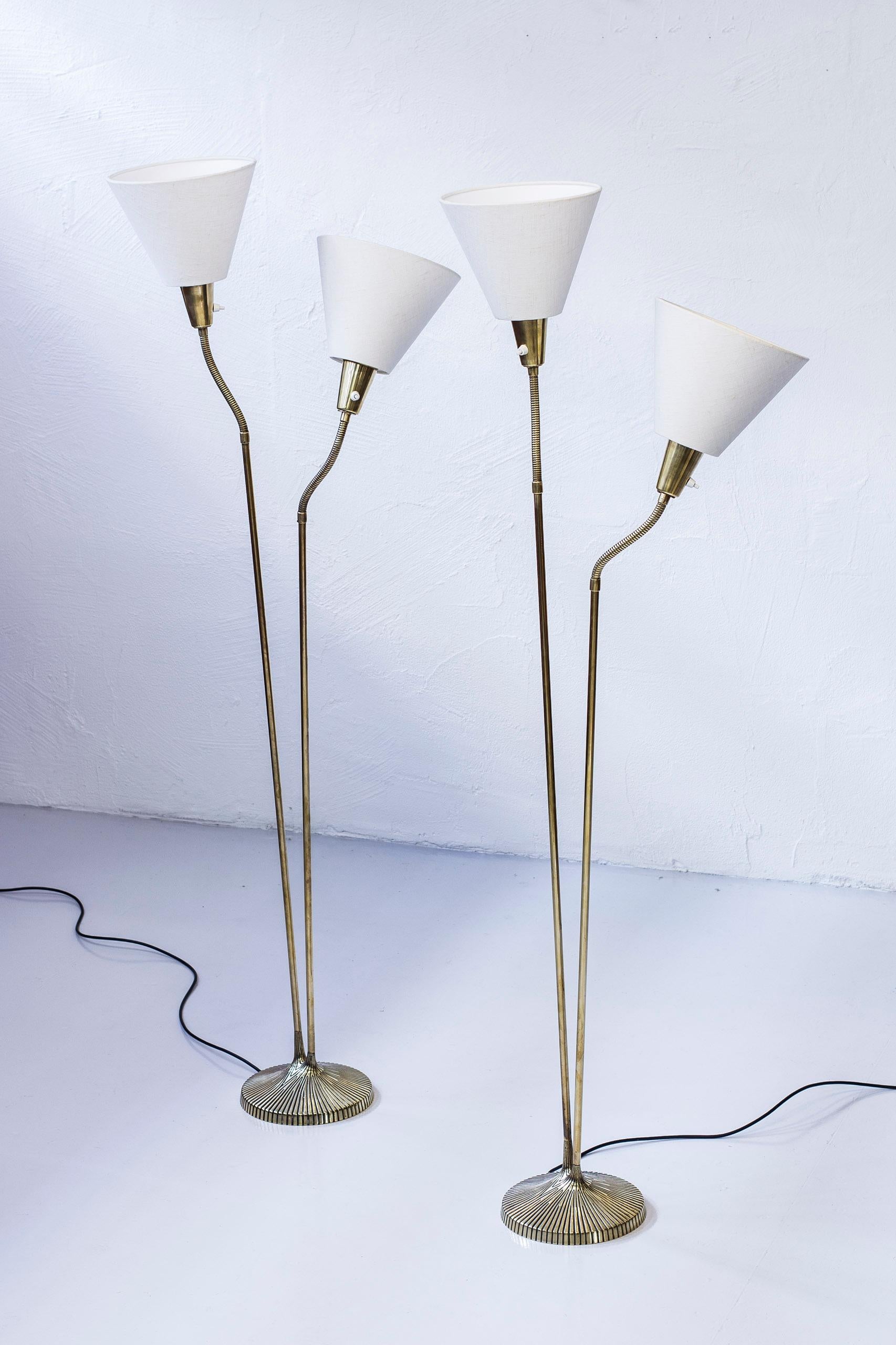Pair of floor lamps designed by Sonja Katzin. Produced by ASEA belysning in the 1950s. Made from solid brass with off-white cotton fabric shades. Light switches on all the lamp fixtures in working order. Good condition with few signs of age related