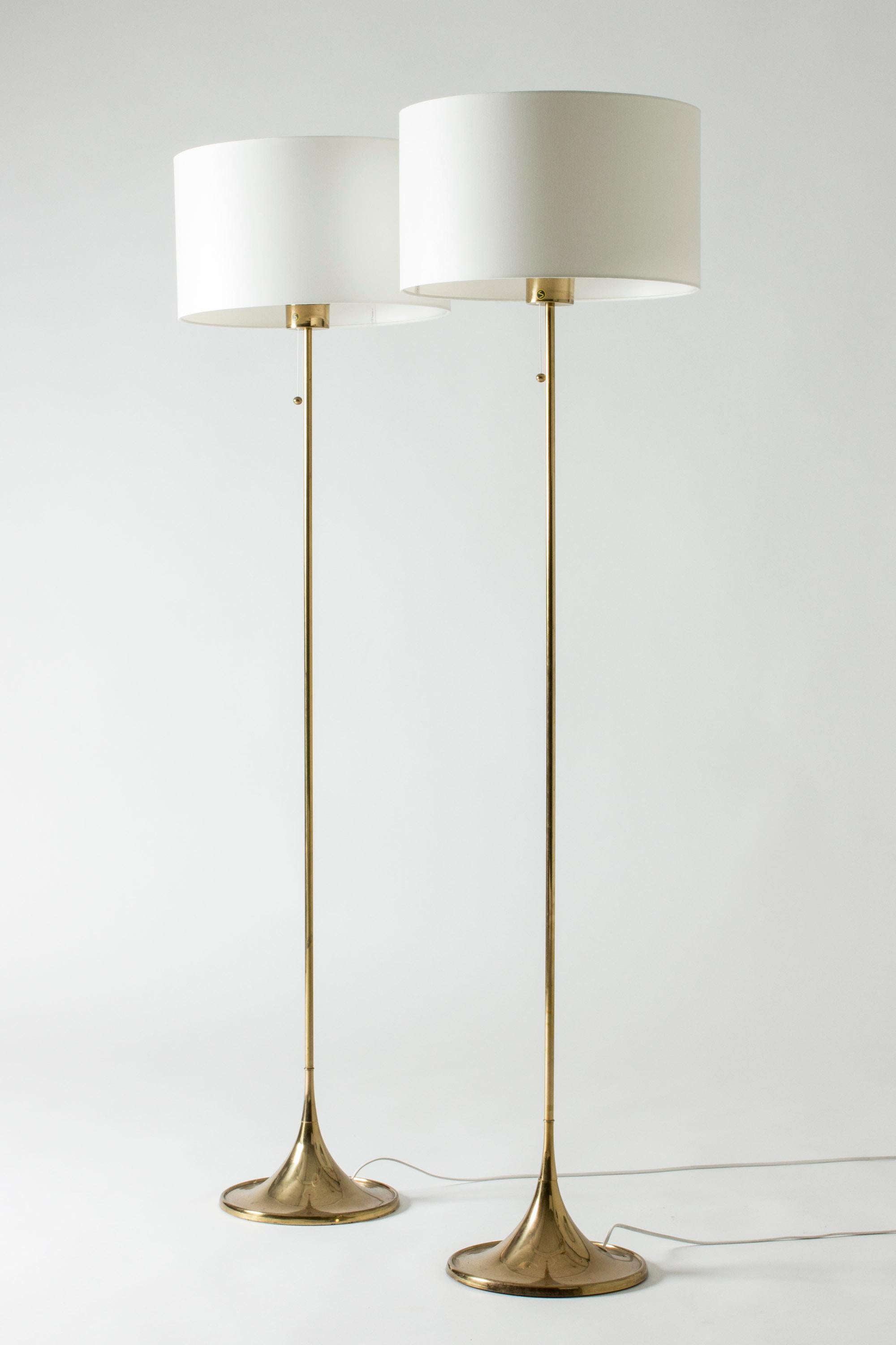 Pair of elegant brass floor lamps from Bergboms, in a sleek, elegant design. Nicely streamlined bases.