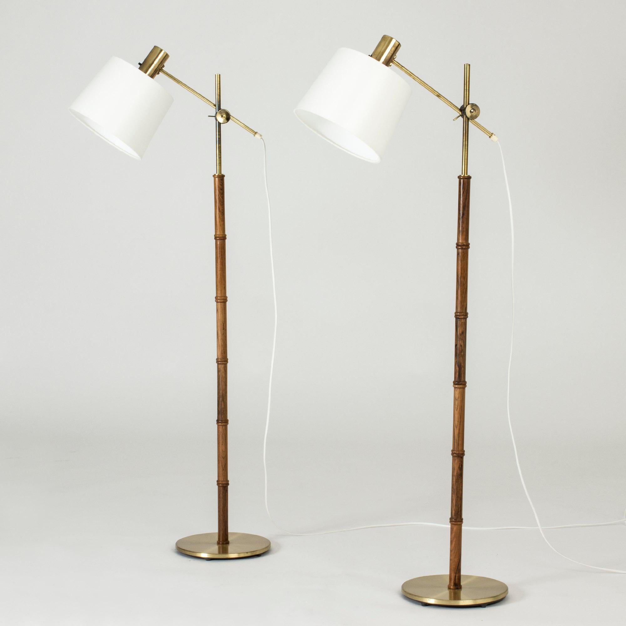 Pair of cool floor lamps from Falkenbergs Belysning, made from brass and wood sculpted in a bamboo stem design. Shades adjustable in height and angles.