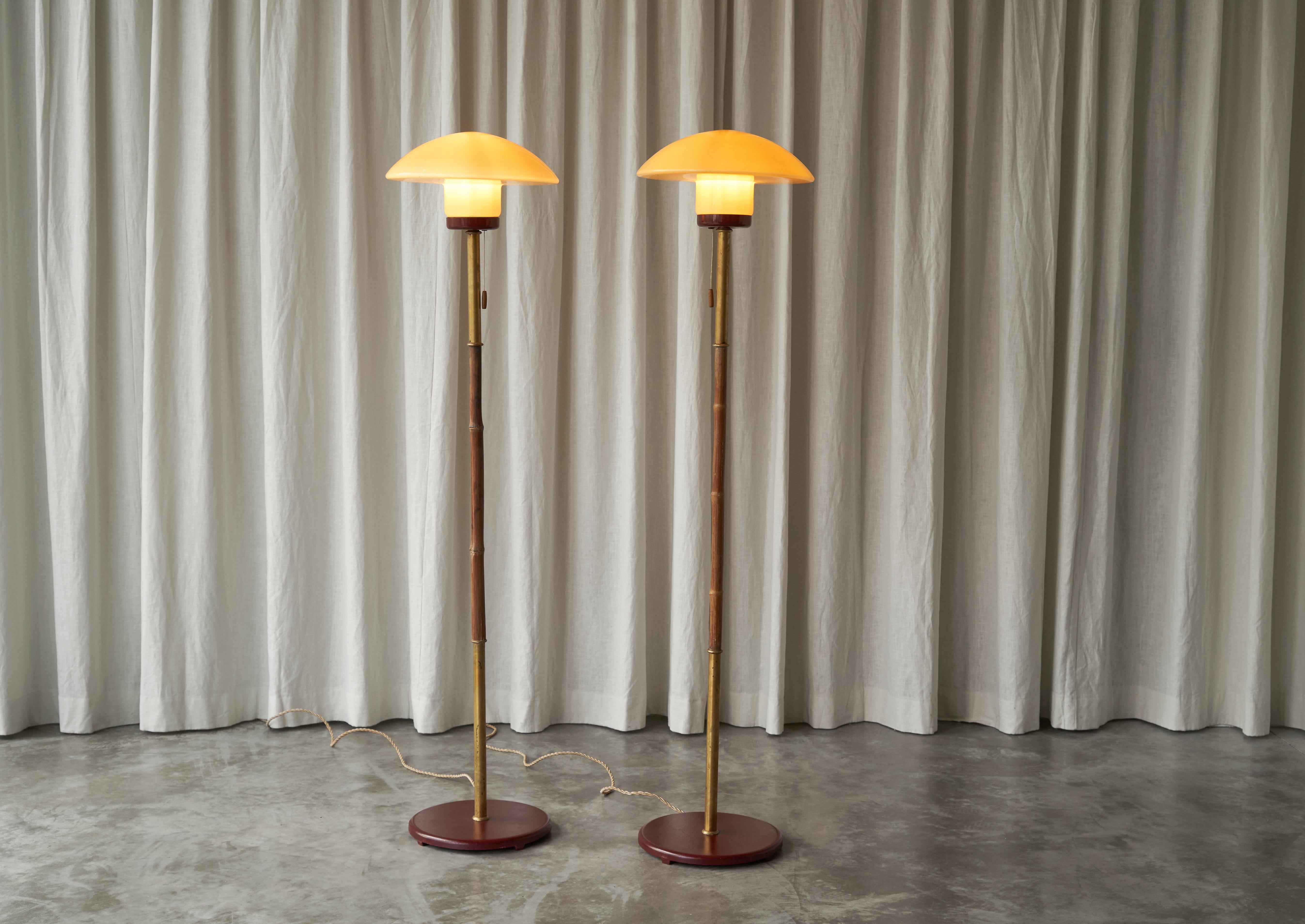 Pair of Floor Lamps in Bamboo, Patinated Brass and Yellow Glass, Europe, 1940s.

This is a very elegant and unusual pair of 1940s floor lamps in metal, bamboo, patinated brass and yellow glass. 

They feature slender columns with both patinated