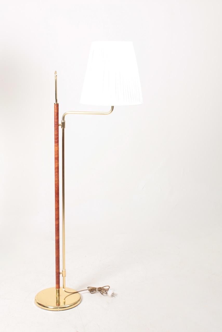 Pair of floor lamps in brass and patinated leather. Designed and made in Sweden in the 1980s. Original condition.