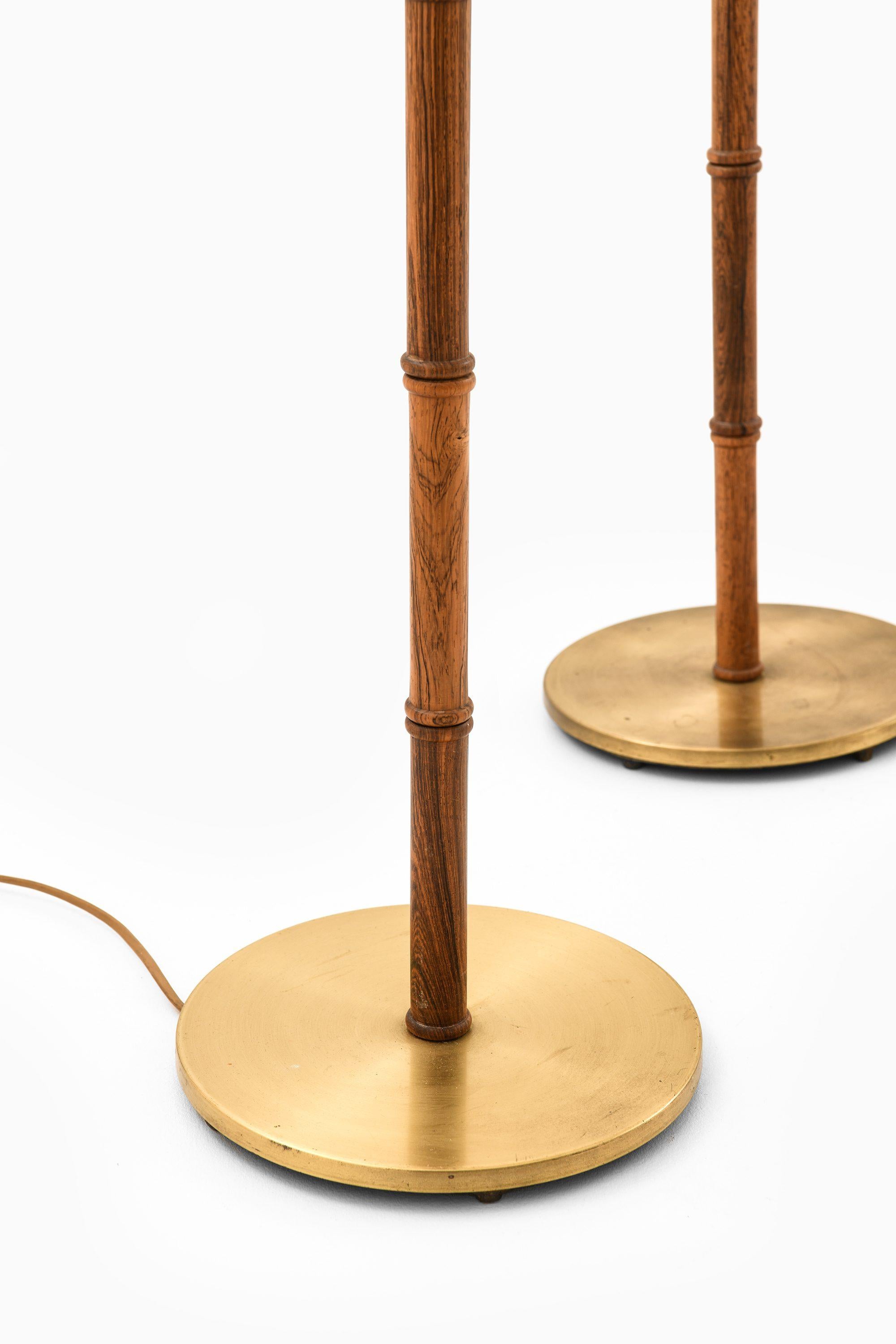 Mid-Century moderno Coppia di lampade da terra in palissandro e ottone, anni '50 in vendita