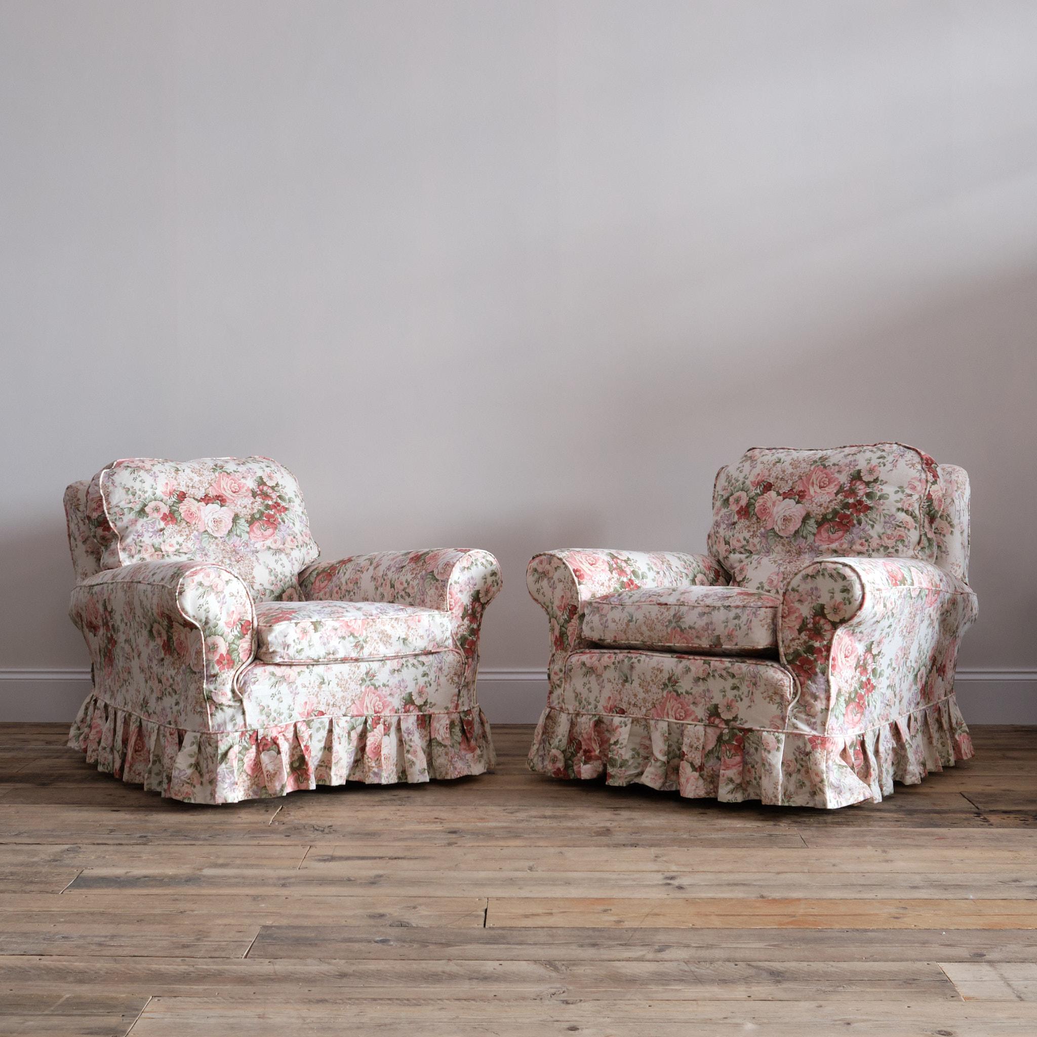 A fabulous pair of large and deep seated country house club chairs. Upholstered in good quality floral print linen slip covers. The upholstery is in good clean condition and very much ready for use. The chairs have soft feather and down seat and