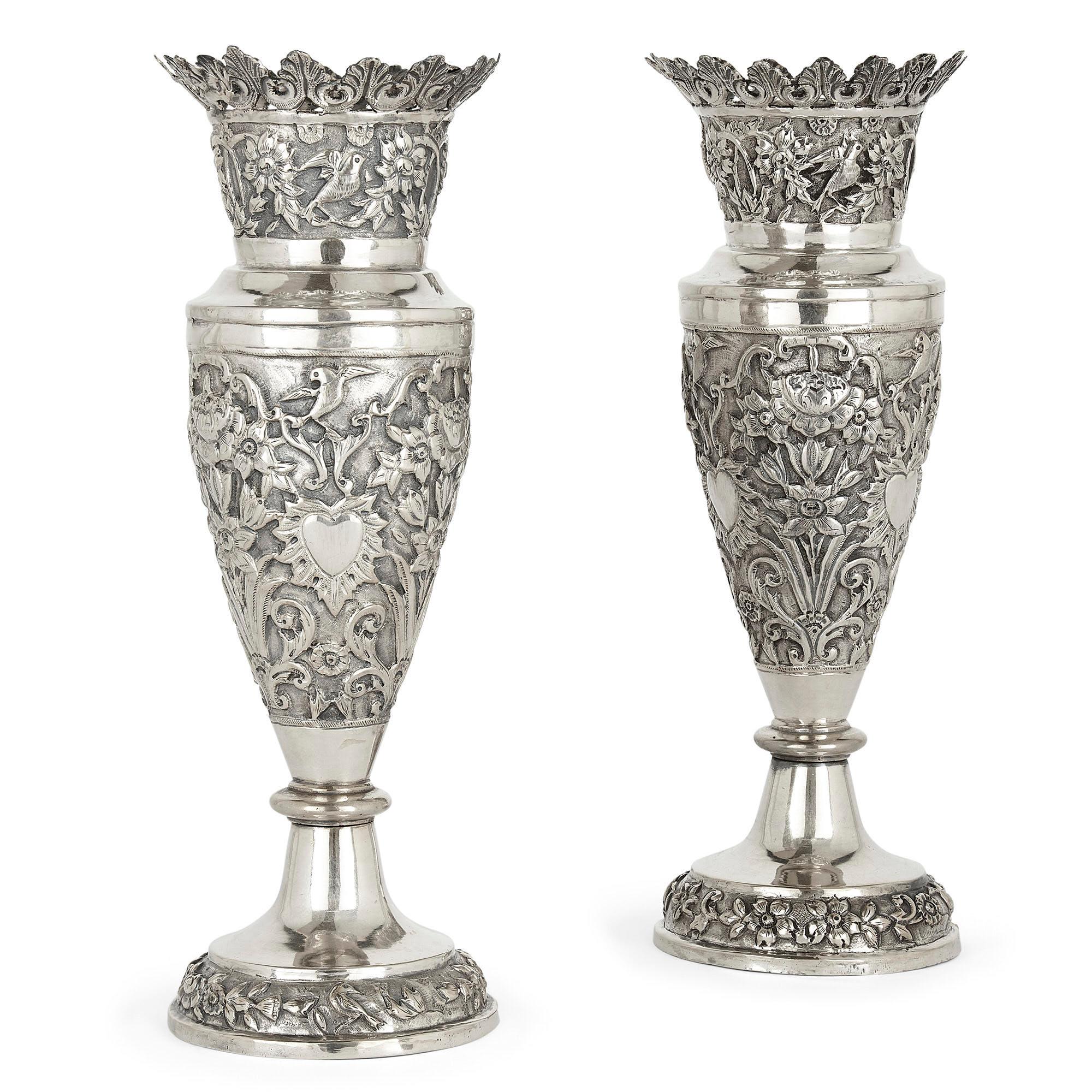 Paire de vases floraux en argent produits en Perse Qajar
Persan, fin du 19e siècle
Mesures : Hauteur 27 cm, diamètre 9,5 cm

Ces vases en argent persan sont ornés de motifs repoussés et ciselés. Chaque vase présente un pied circulaire orné de
