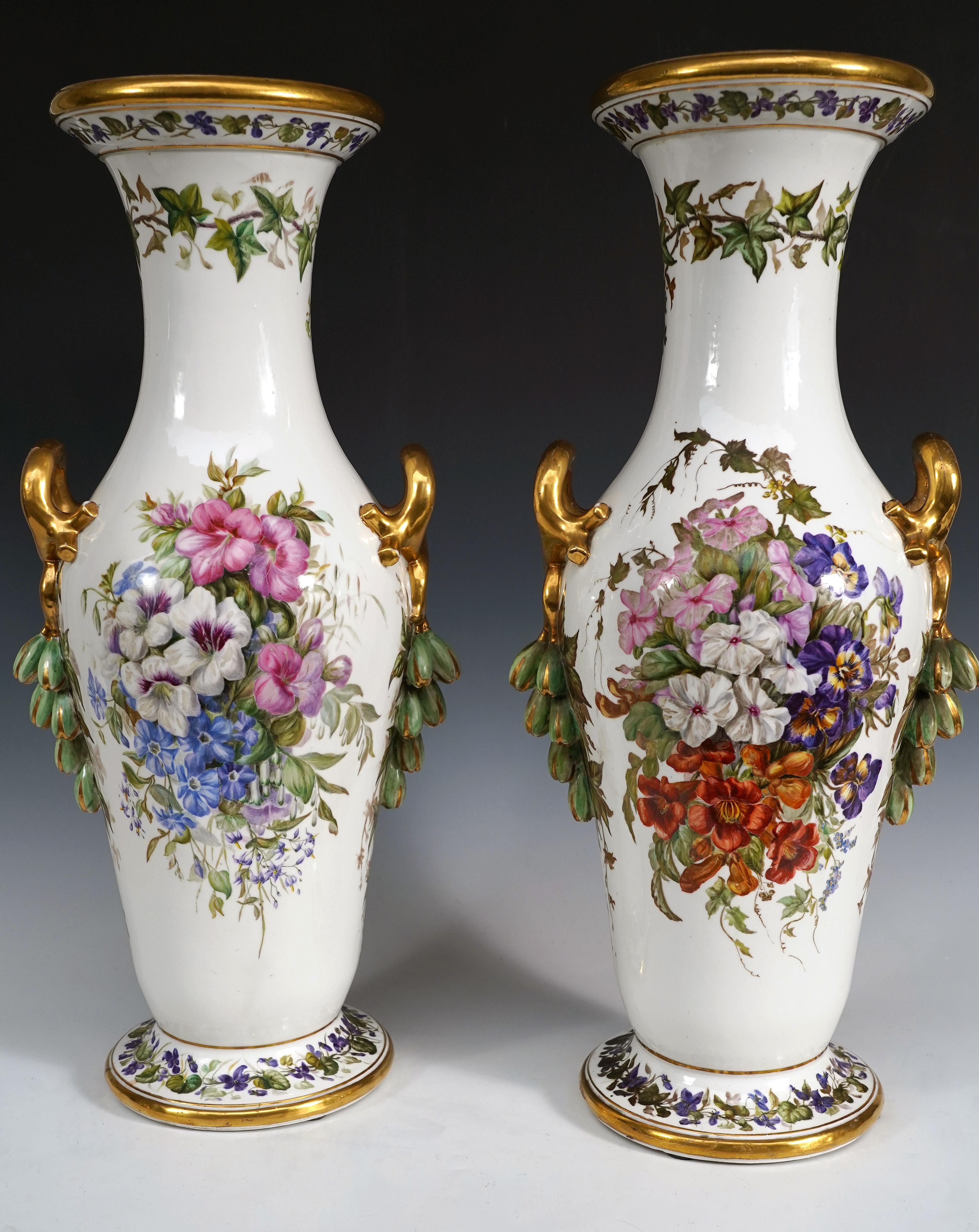 Designer’s mark AS on the base

Beautiful pair of baluster-shaped vases in white porcelain, richly decorated on all four sides with beautiful polychrome floral compositions framed by gilded porcelain handles from which bunches of flowers fall.
The
