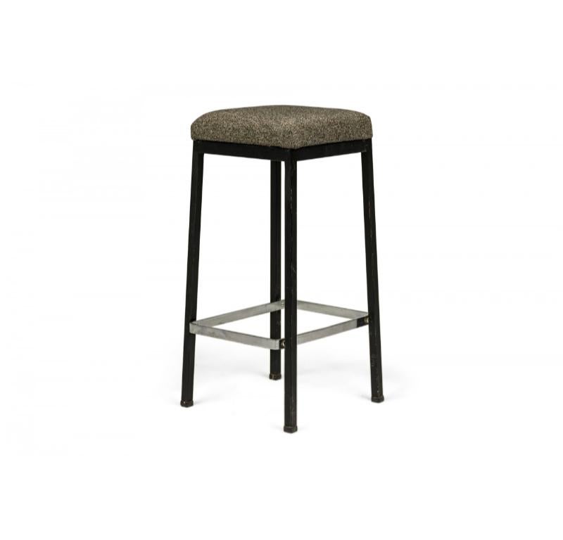 Paire de tabourets de bar américains du milieu du siècle reposant sur des pieds rectangulaires en métal noir, ancrés par un châssis en métal argenté. L'assise est tapissée d'un motif tissé poivre et sel dans un ton neutre (FLORENCE KNOLL POUR KNOLL