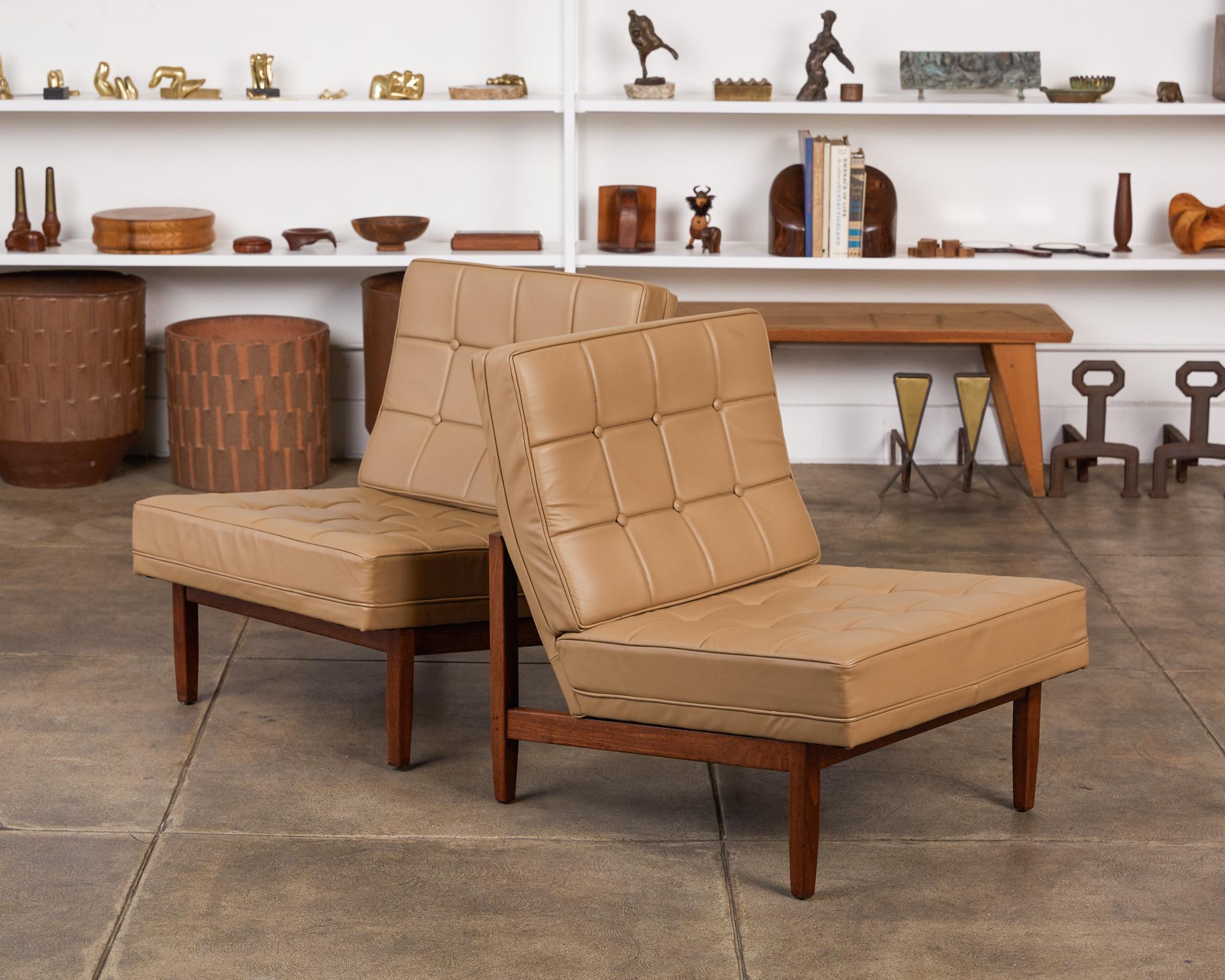 Pair of slipper lounge chairs by Florence Knoll, USA, circa 1950s. The chairs feature a walnut frame with attached tufted leather back and seat cushions. A Classic design by one of the matriarchs of American Modernist furniture