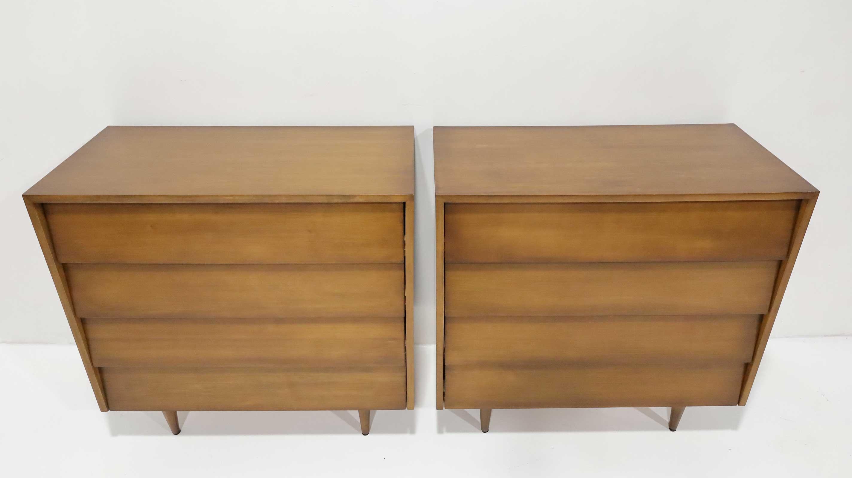 Beautiful pair of chests of drawers or nightstands in an iconic design by Florence Knoll. Louvered drawers on raised turned wood legs imbue a timeless design. 