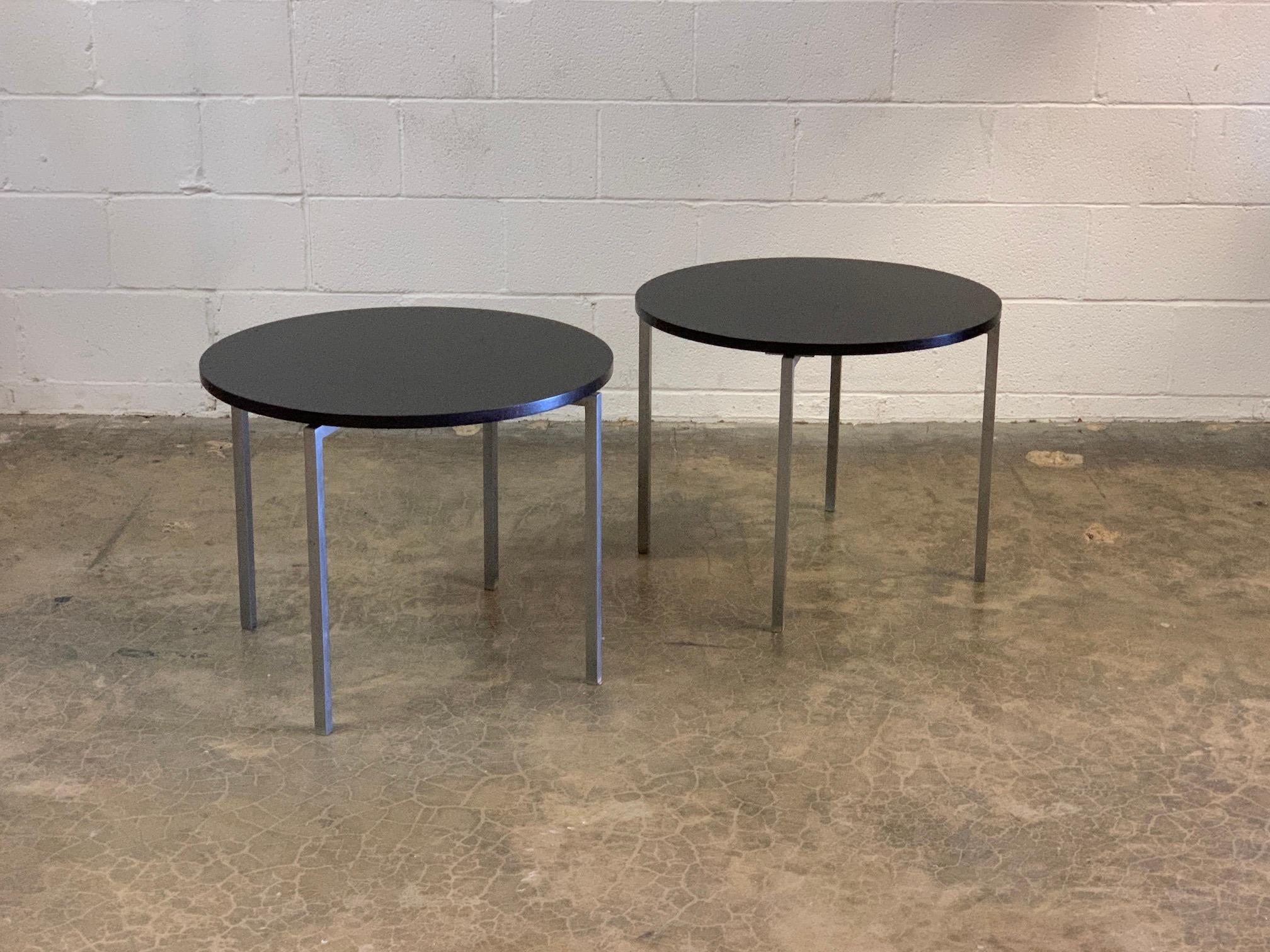 A pair of early brushed steel tables with ebonized wood tops. Designed by Florence Knoll for Knoll.