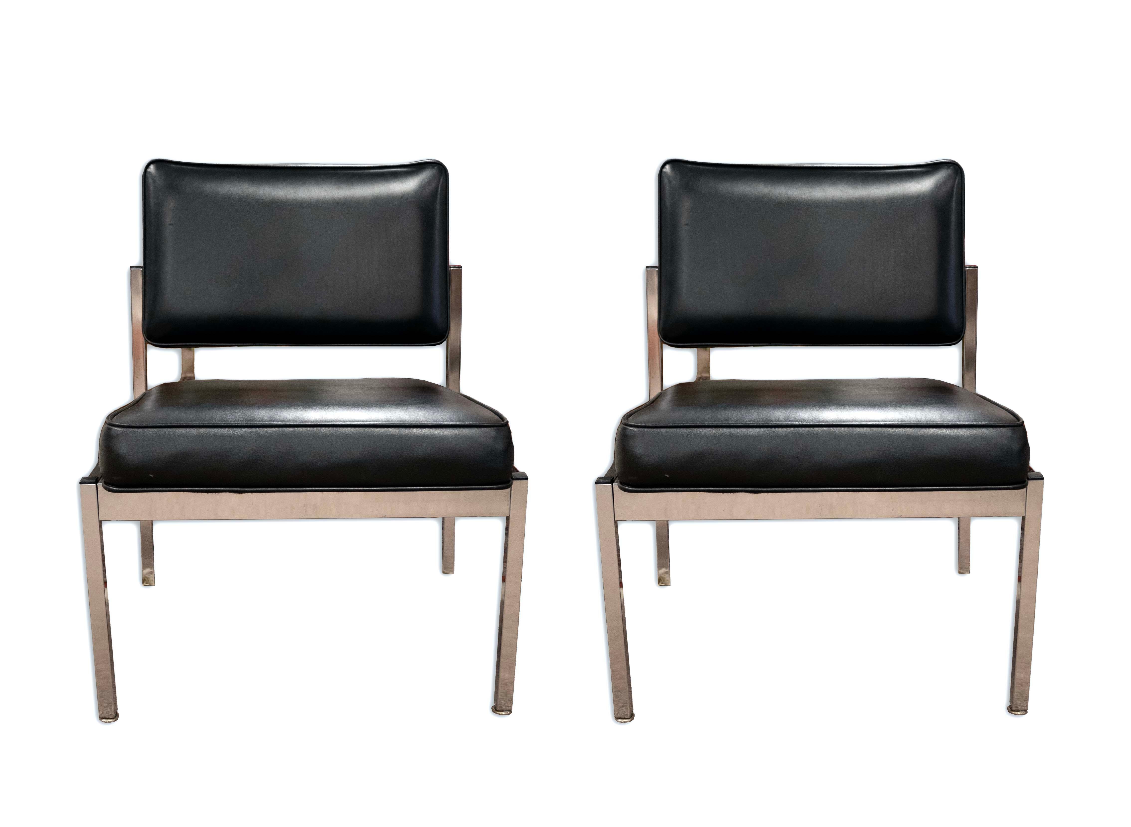 A pair of “Slipper Chairs” designed by Florence Knoll. Circa 1960s. Brushed stainless steel frames upholstered in black leather. Classic mid-century modern design feature sturdy frames with a sleek chrome finish, thickly padded, and comfortable