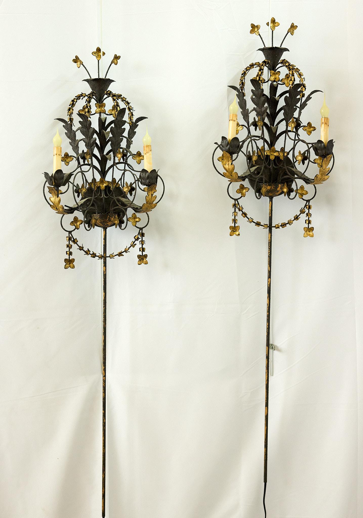 Merveilleuse paire d'appliques murales du 20e siècle, de style Florentine classique, avec des feuilles d'acanthe enroulées, des fleurs dorées et des guirlandes de campanules. Chaque applique contient deux bras de candélabre avec des manchons de