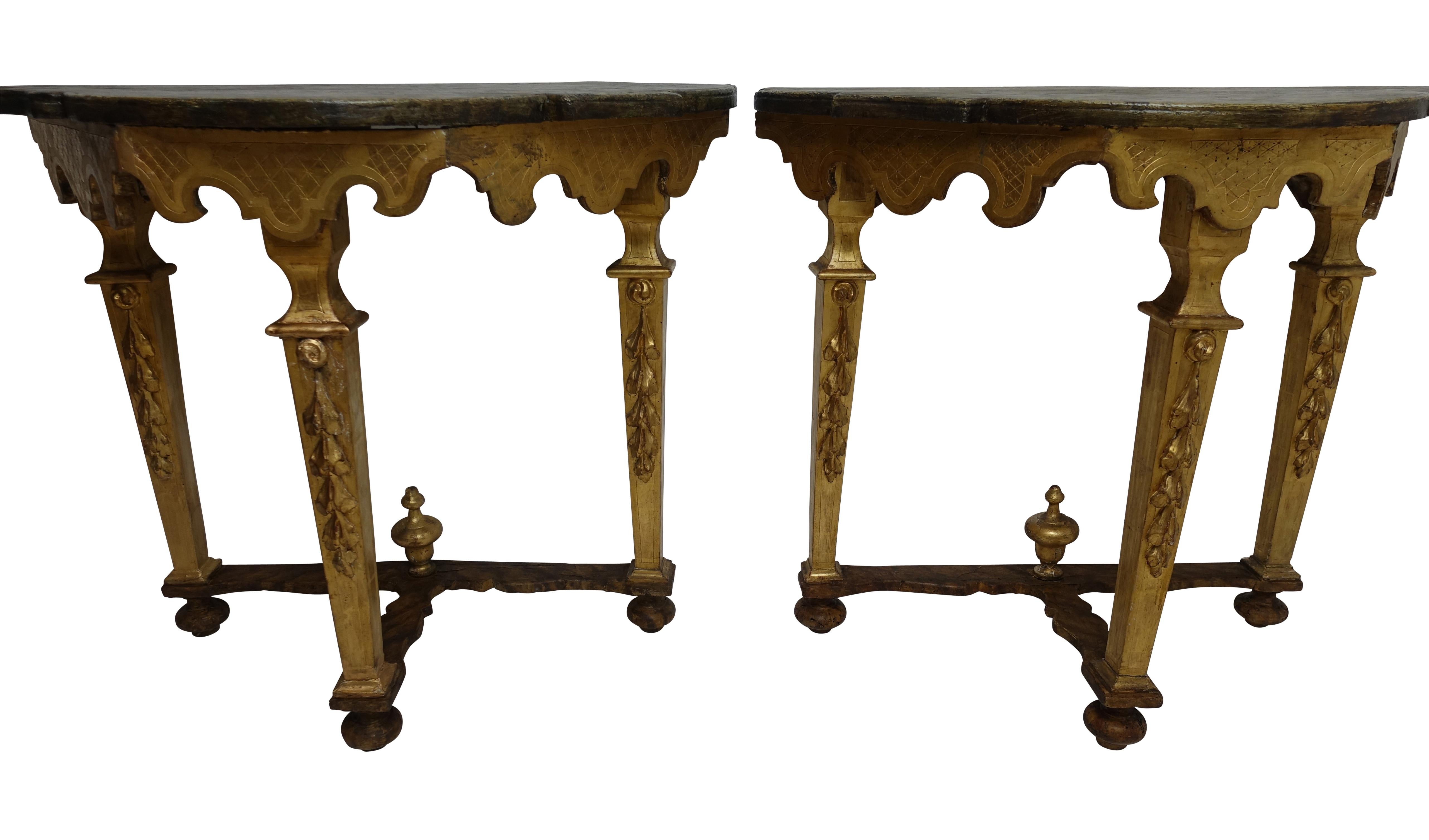 A wonderful pair of old Florentine style hand-carved and gessoed console tables with a later faux marbleized finish on the top and stretcher, having a gilt scalloped apron, standing on three canted supports and sitting on bun feet, Italy, 18th