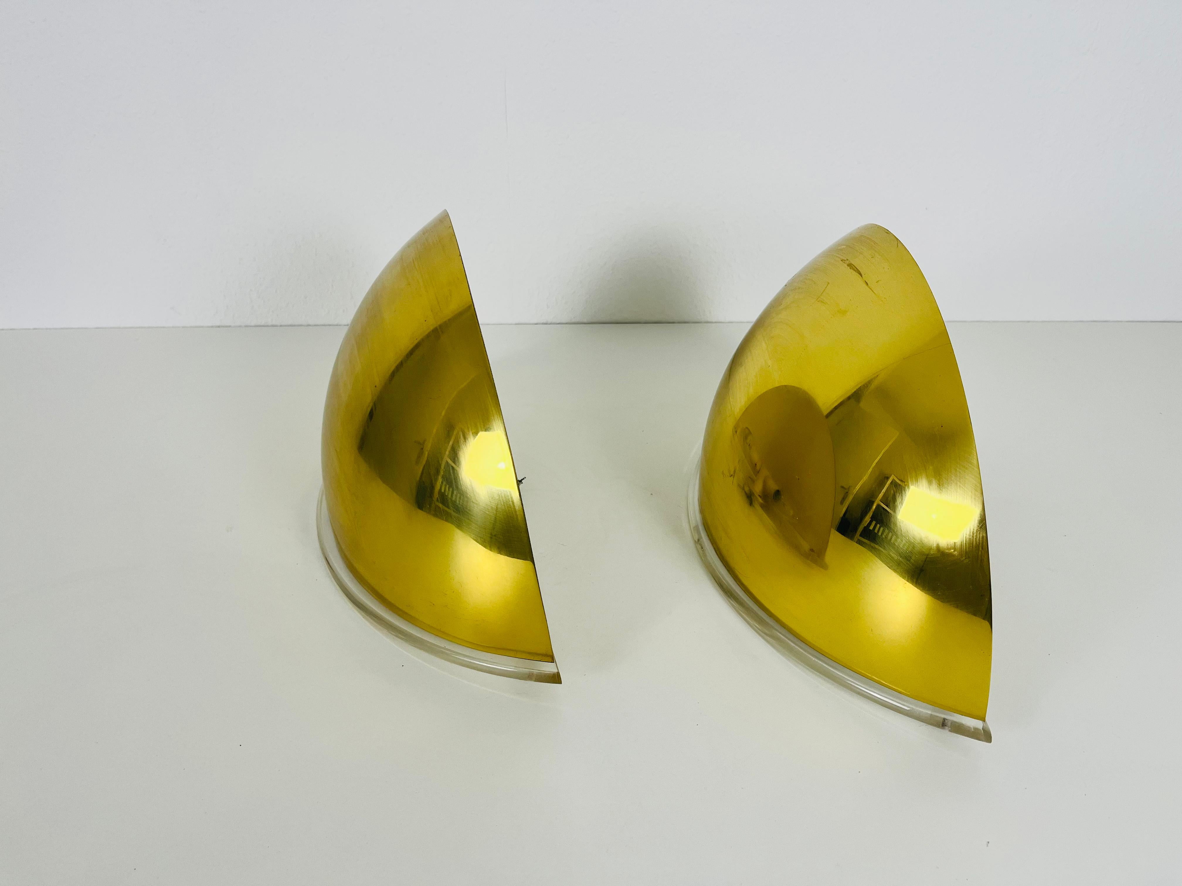Ein Paar Wandlampen von Florian Schulz, hergestellt in Deutschland in den 1970er Jahren. Sie fasziniert mit ihrem vergoldeten Messingschirm und dem Plexiglasfuß.

Die Leuchte benötigt E14-Glühbirnen. Funktioniert sowohl mit 110/220 V. Guter alter