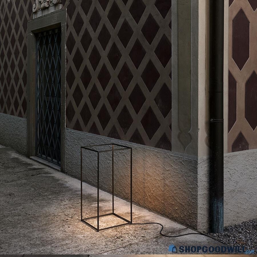 A single Ipnos Outdoor Rectangular Floor Lamp, made with a bronzed extruded aluminum frame and transparent polycarbonate diffuser. The lamp was designed by Nicoletta Rossi and Guido Bianchi and produced by Flos in Italy, and dates to circa 2021.