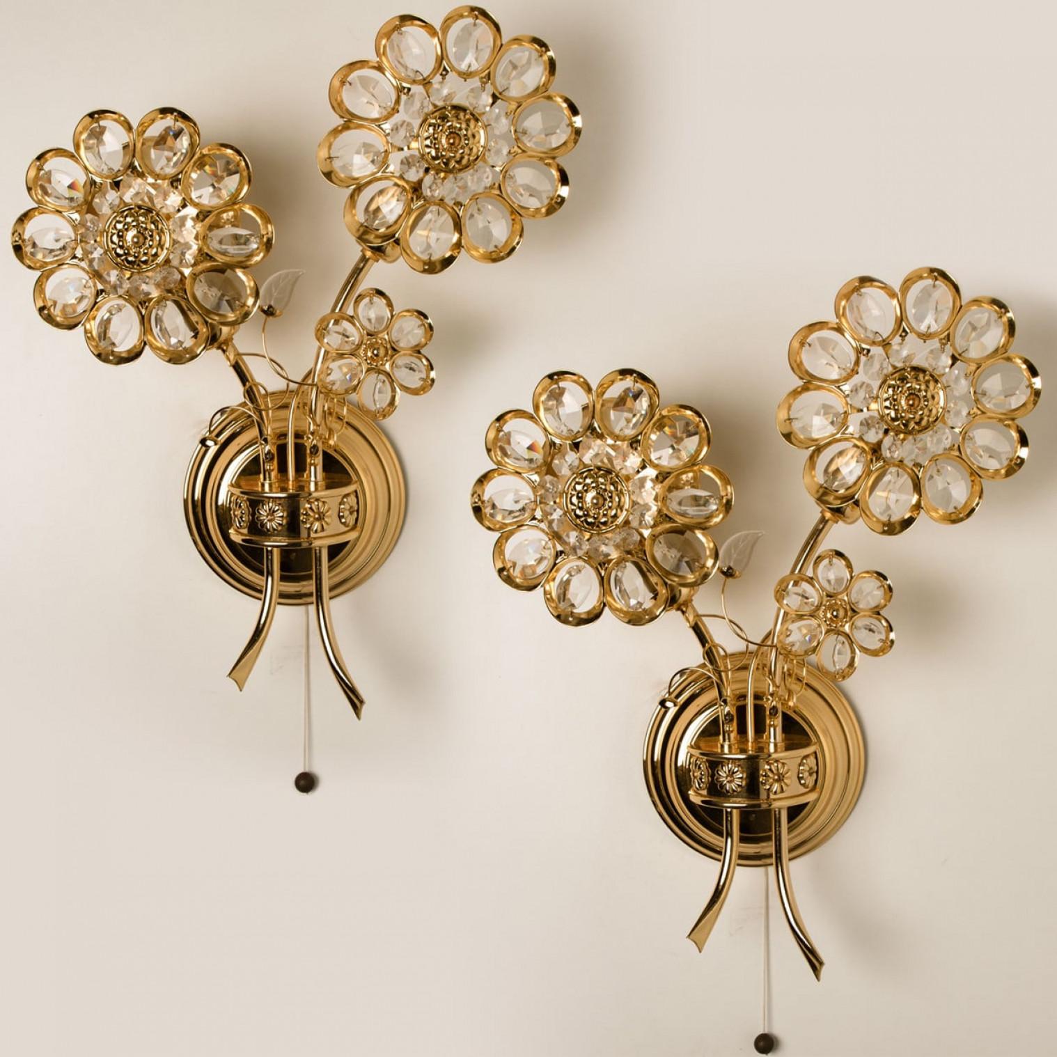 Two stunning gilt and crystal wall-mounted sconces by Palwa, Germany, circa 1965-1975.
These most luxurious of wall lights feature beautifully cut crystals in the form of flowers and petals set on a gold-plated brass frame.

Please notice the price