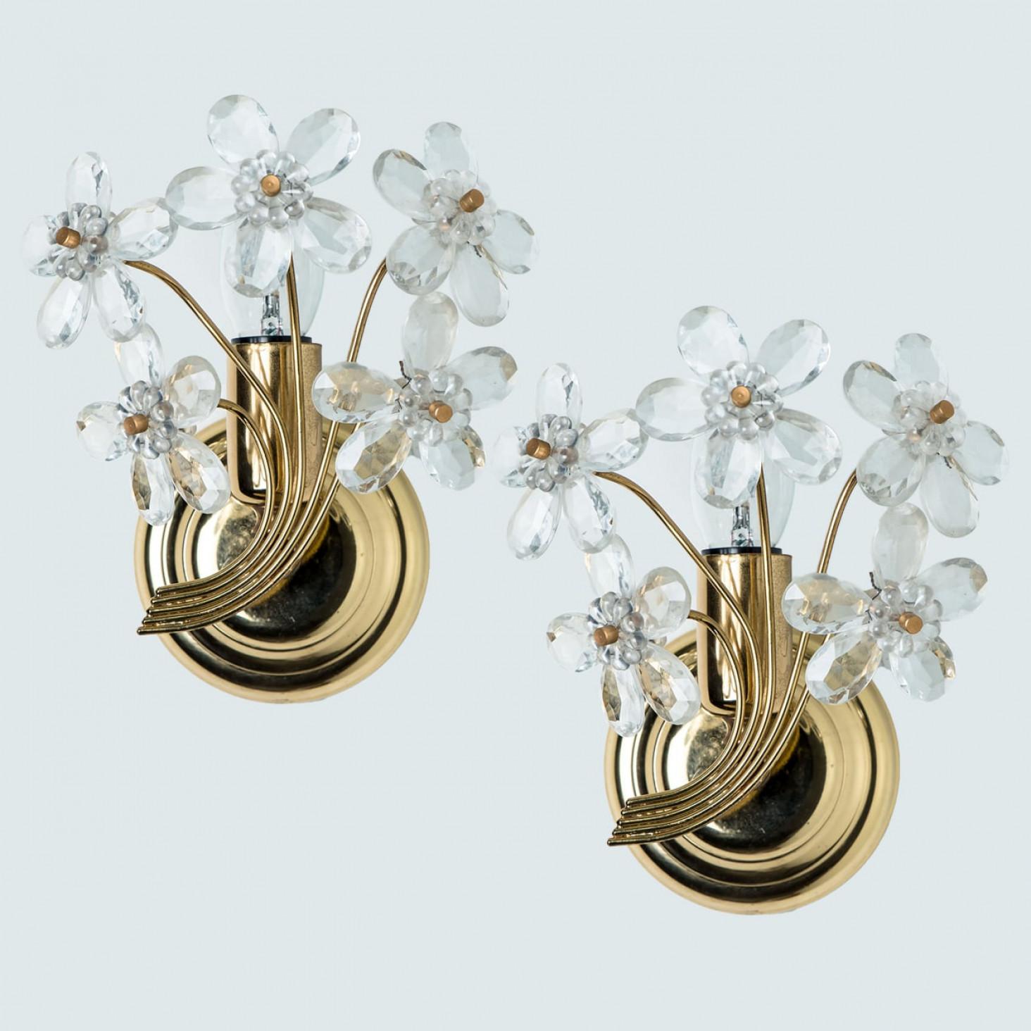 A pair of stunning gilt and crystal wall-mounted sconce by Palwa, Germany. Manufactured around 1965-1975.
This luxurious wall light features beautifully cut crystals in the form of five flowers and petals set on a gold-plated brass