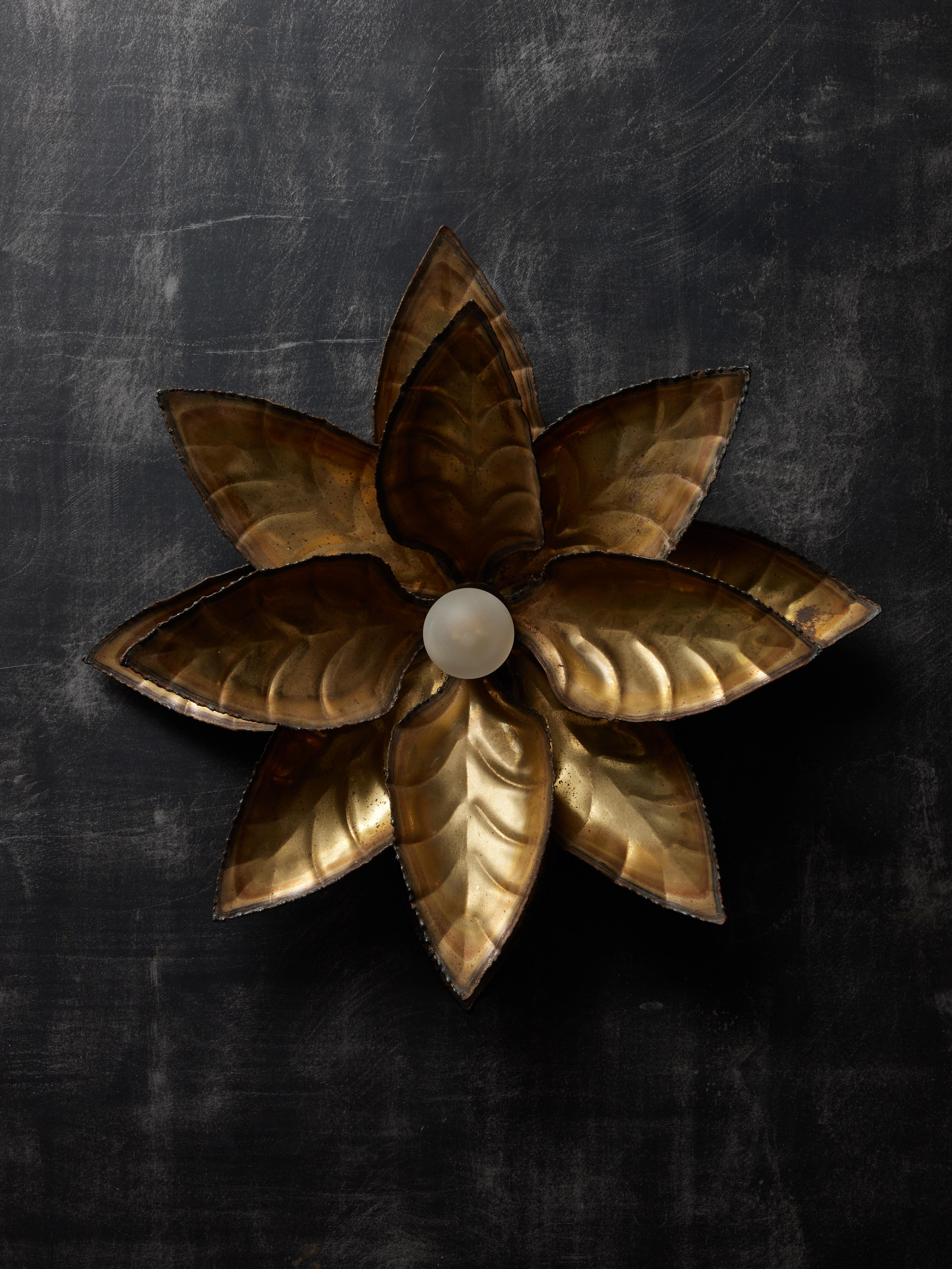 Pair of vintage wall sconces, shaped like an open flower and entirely made of patinated brass. Each sconce has one single light source in its center.