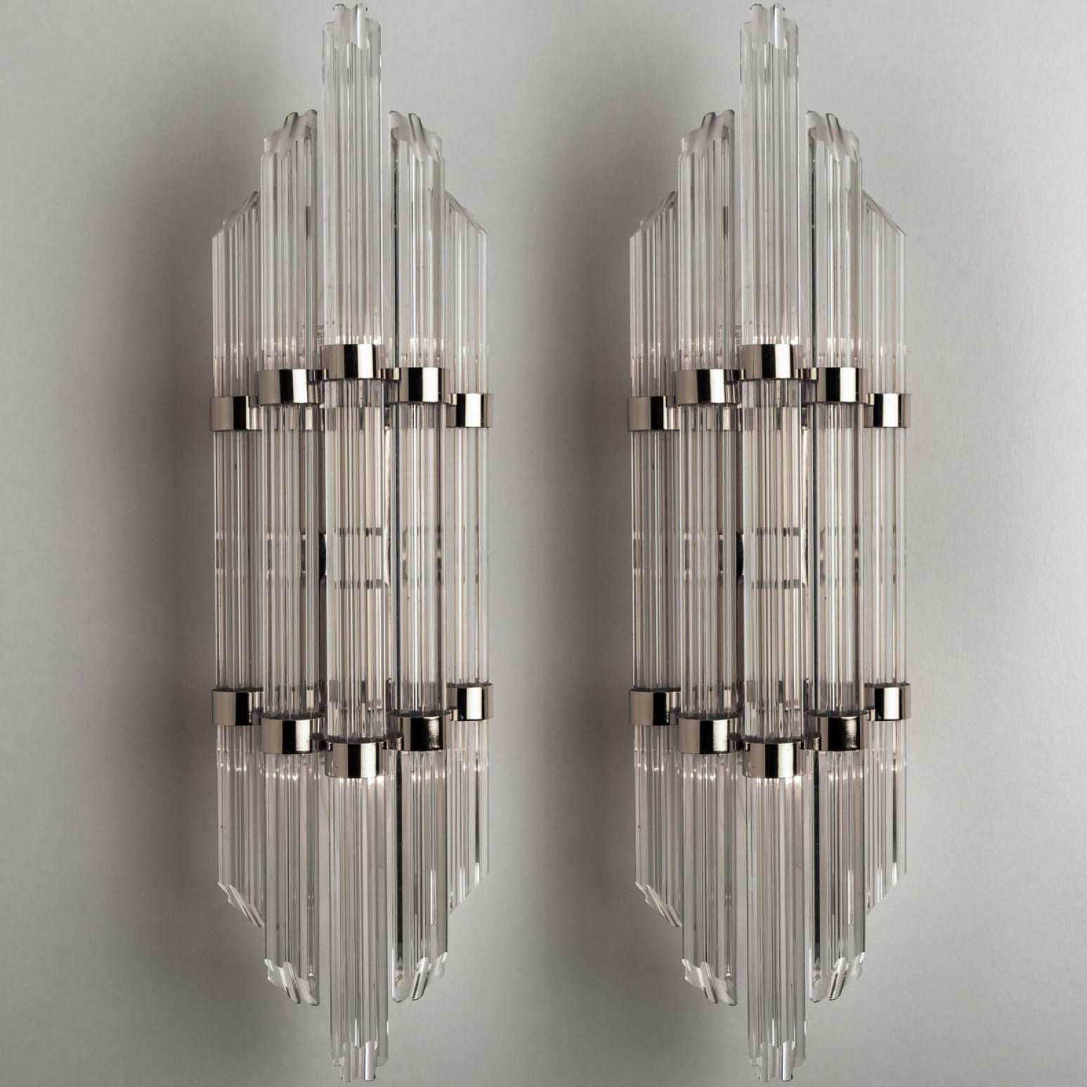 Wonderful high-end wall sconces in the style of Sciolari. With flower shaped glass 'tubes' and chrome details giving each piece an elegant appearance which refracts the light, filling a room with a soft, warm glow.
The wall sconce has a chrome back