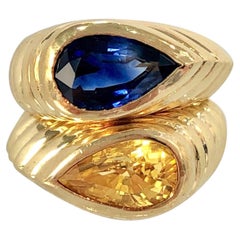 Pareja de anillos de oro estriados con zafiros azules y amarillos en forma de pera de Niva