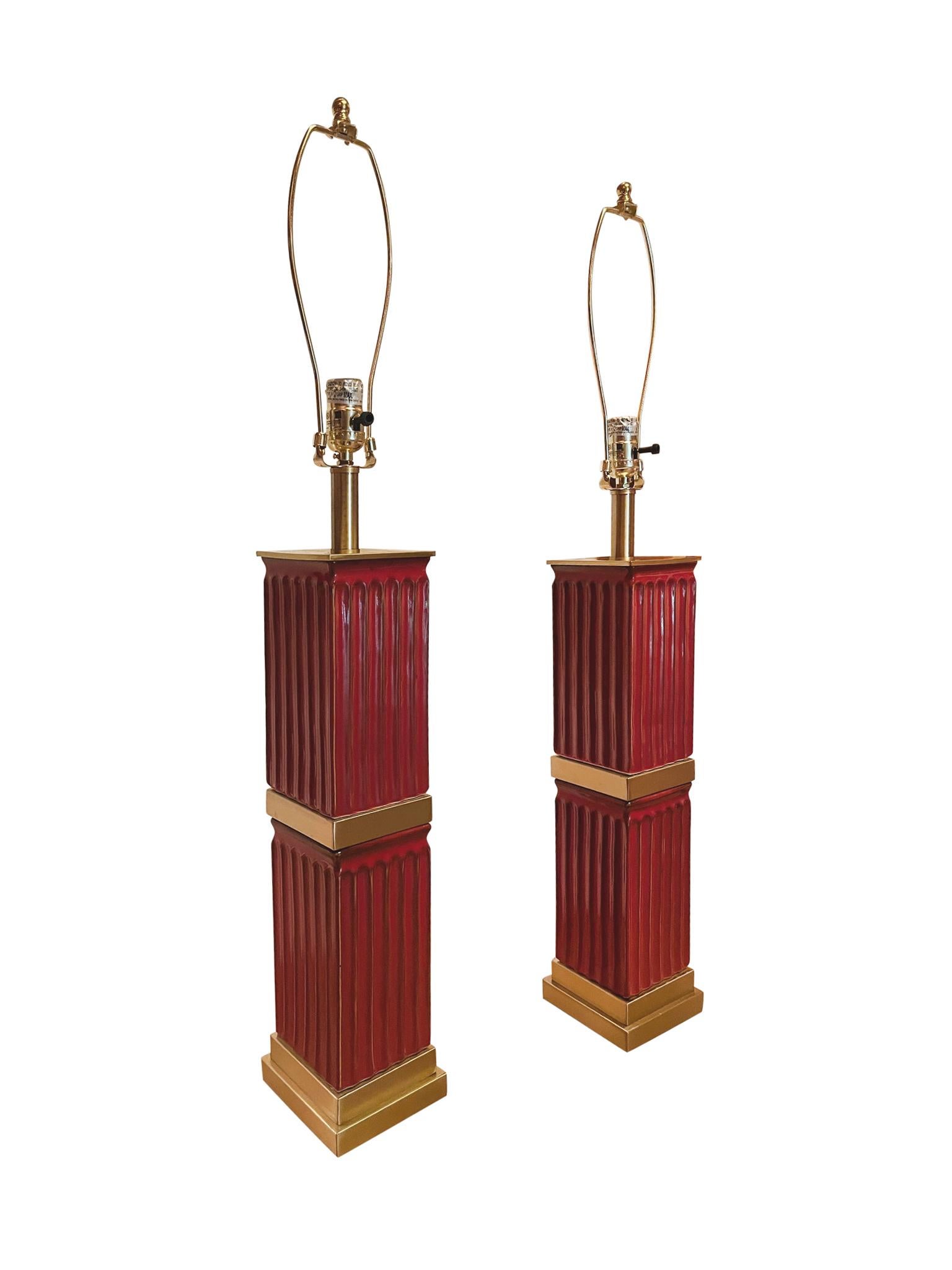 Paire de lampes de table en céramique de style néoclassique en émail rouge avec des détails en laiton doré. Les lampes ont été refaites à neuf et sont associées à de nouveaux abat-jour et harpes en lin, ajustés sur mesure. Ces lampes éclaireront