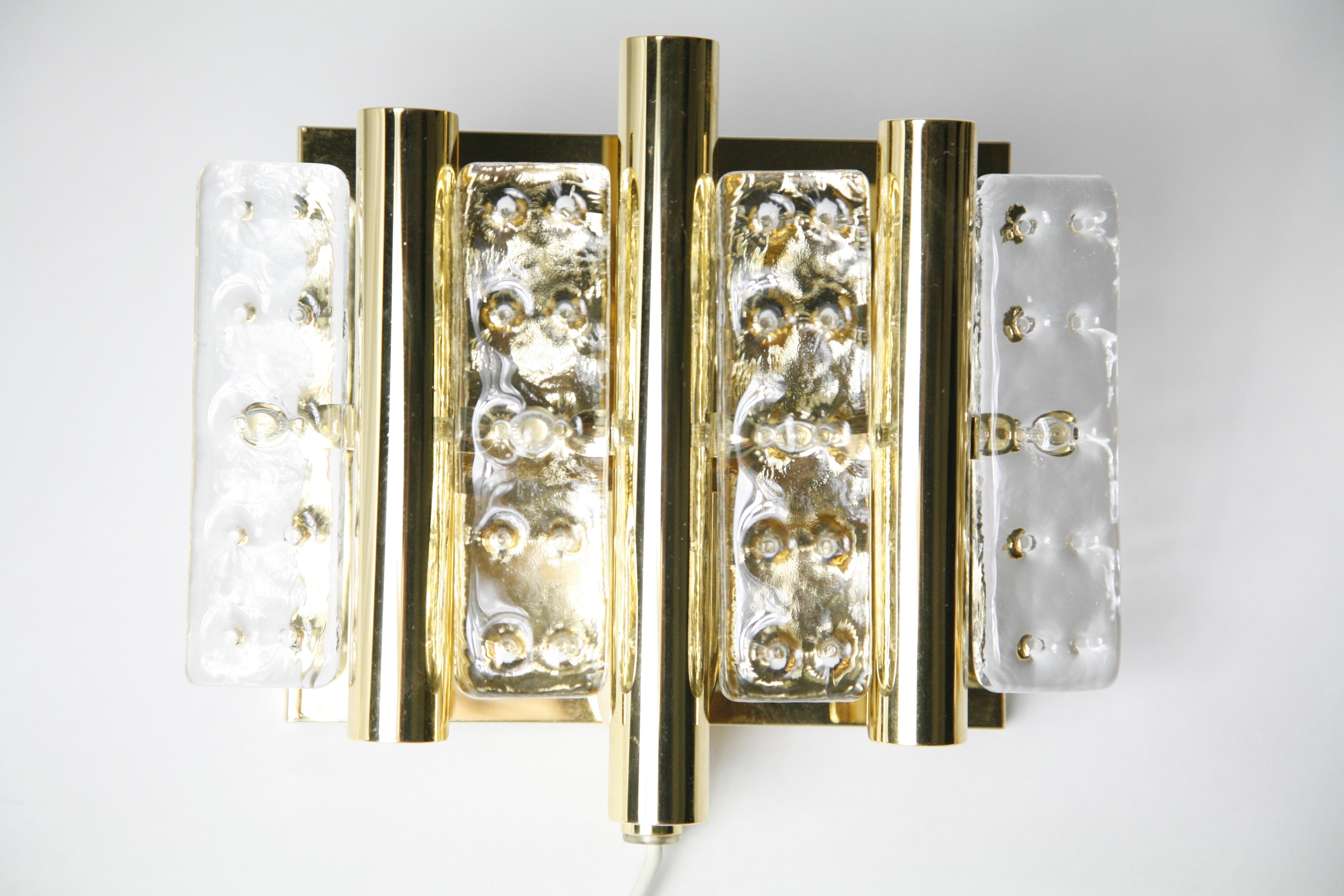 Pair of Flygsfors brass sconces glass elements, Sweden, 1970, brass bases that is gilded with 4 pieces og pressed crystal glass as shades on each sconce in excellent condition.
Hold one candelabra bulb each.