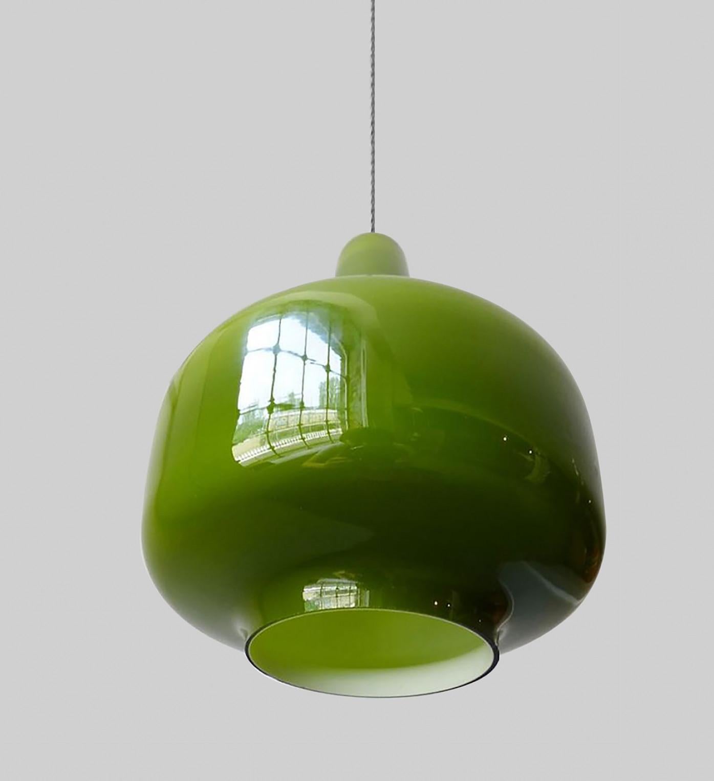 Pair of modernist wall lamps in beautiful warm green-colored glass. With lovely steel or transparent cable for a clean modern look.
We can deliver different colors of cables and ceiling cups (also purple).

Designed and made in Sweden by Hans-Agne