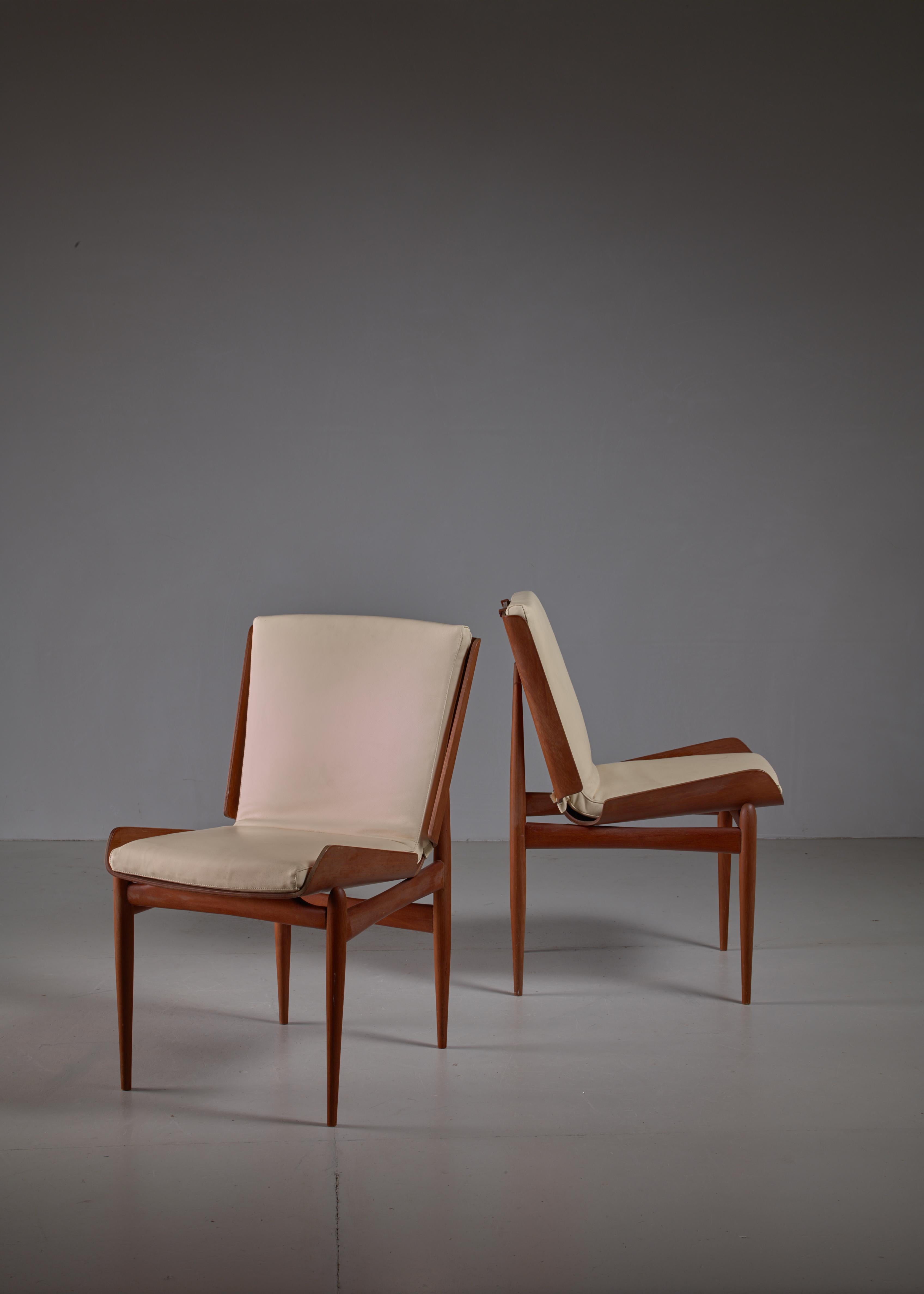 A beautiful pair of side chairs. The seat is made of folded plywood with
a white leather seat pad that is attached to the seat with a beautiful wooden clasp at the top (see image 6) and a slim white leather belt at the bottom. The plywood seats are