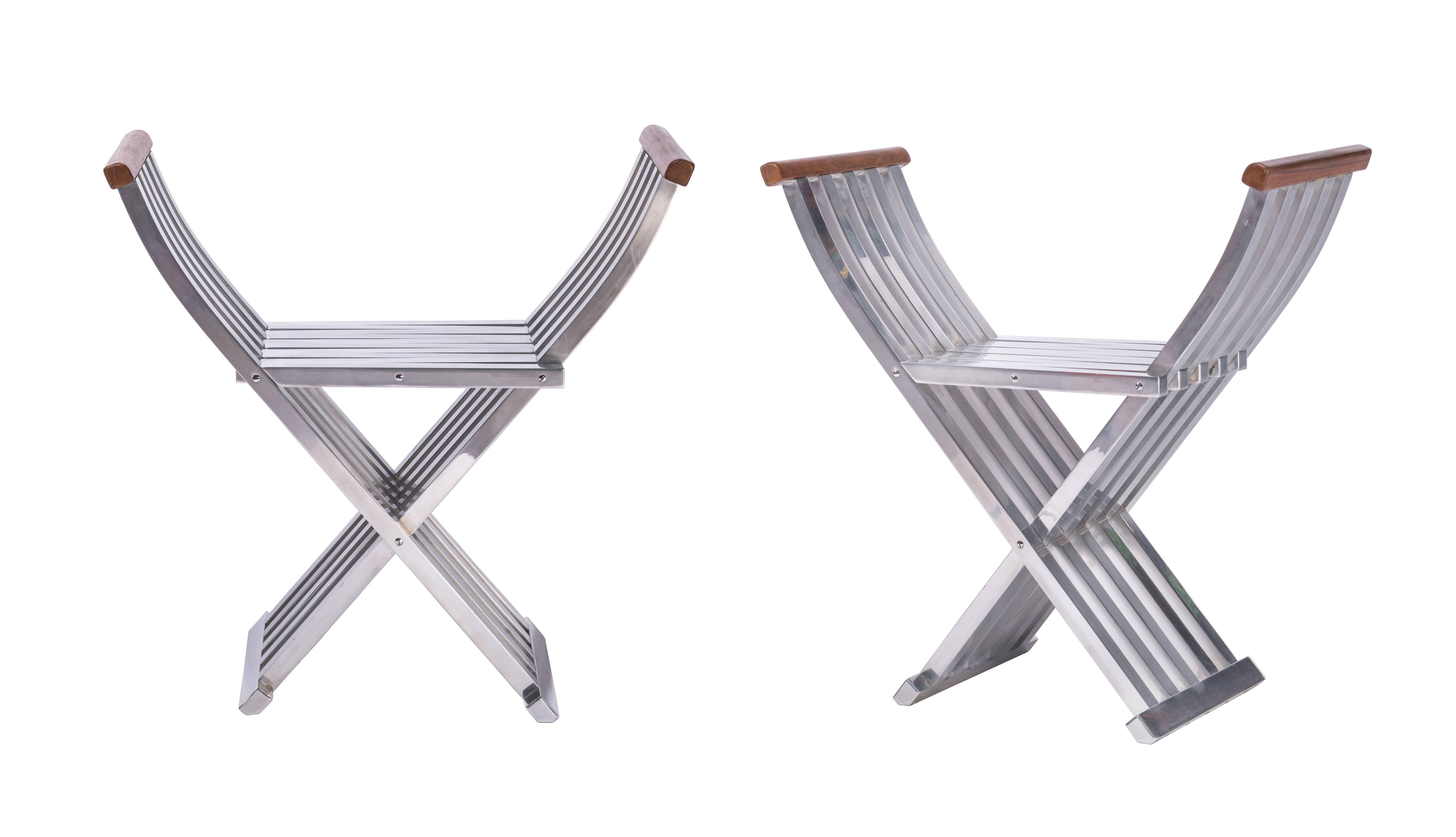 A beautiful pair of extremely well engineered and designed folding benches from John Vesey. Made from brushed and lacquered aluminum with walnut handles. Bench seats with some age appropriate minor scratching.