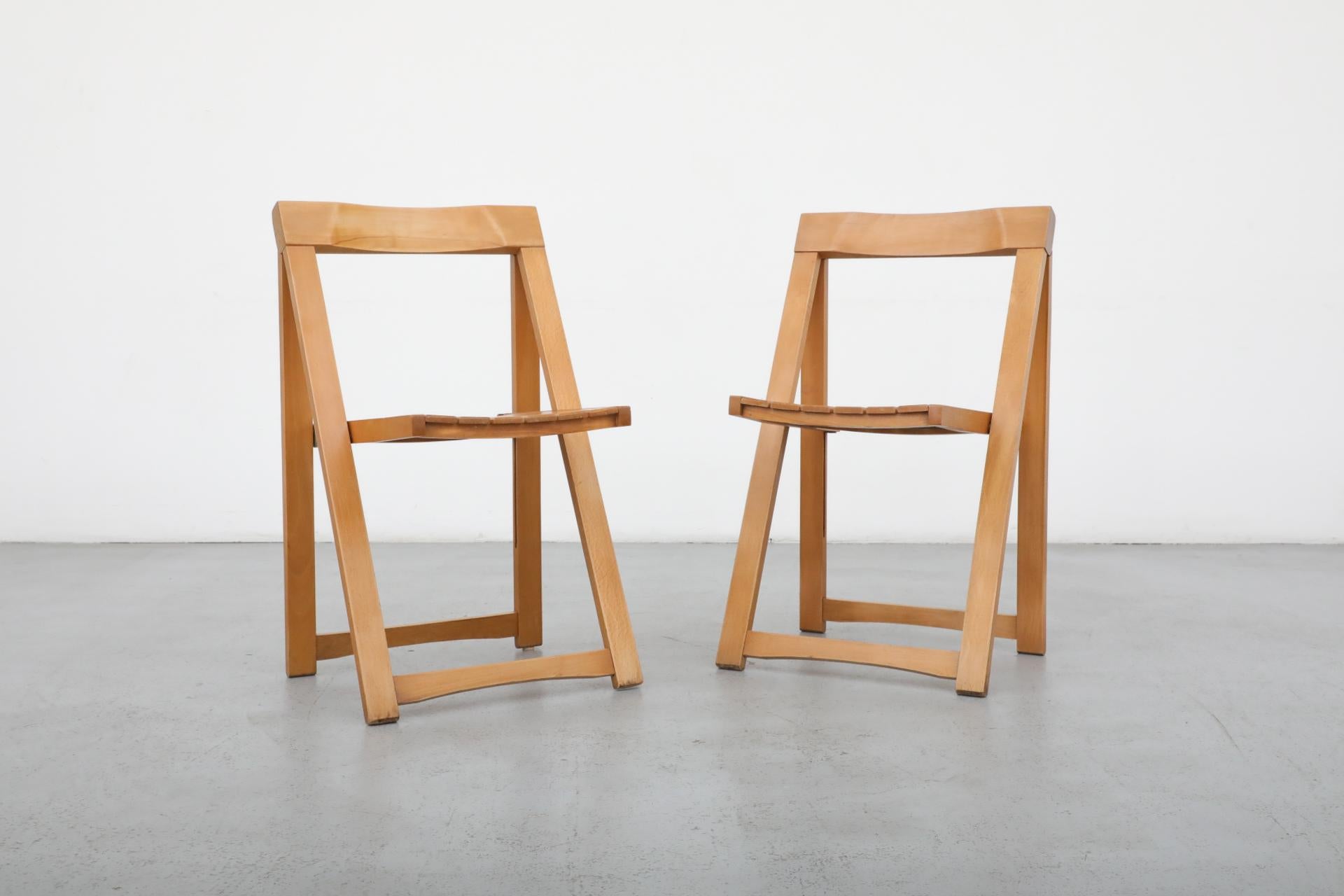 Pair Aldo Jacober folding chairs for Alberto Bazzani. Folded up they measure 18 x 1.625 x 34.875. In original condition with visible wear and chipping to the finish. The wear is consistent with their age and use. Several other similar folding chairs