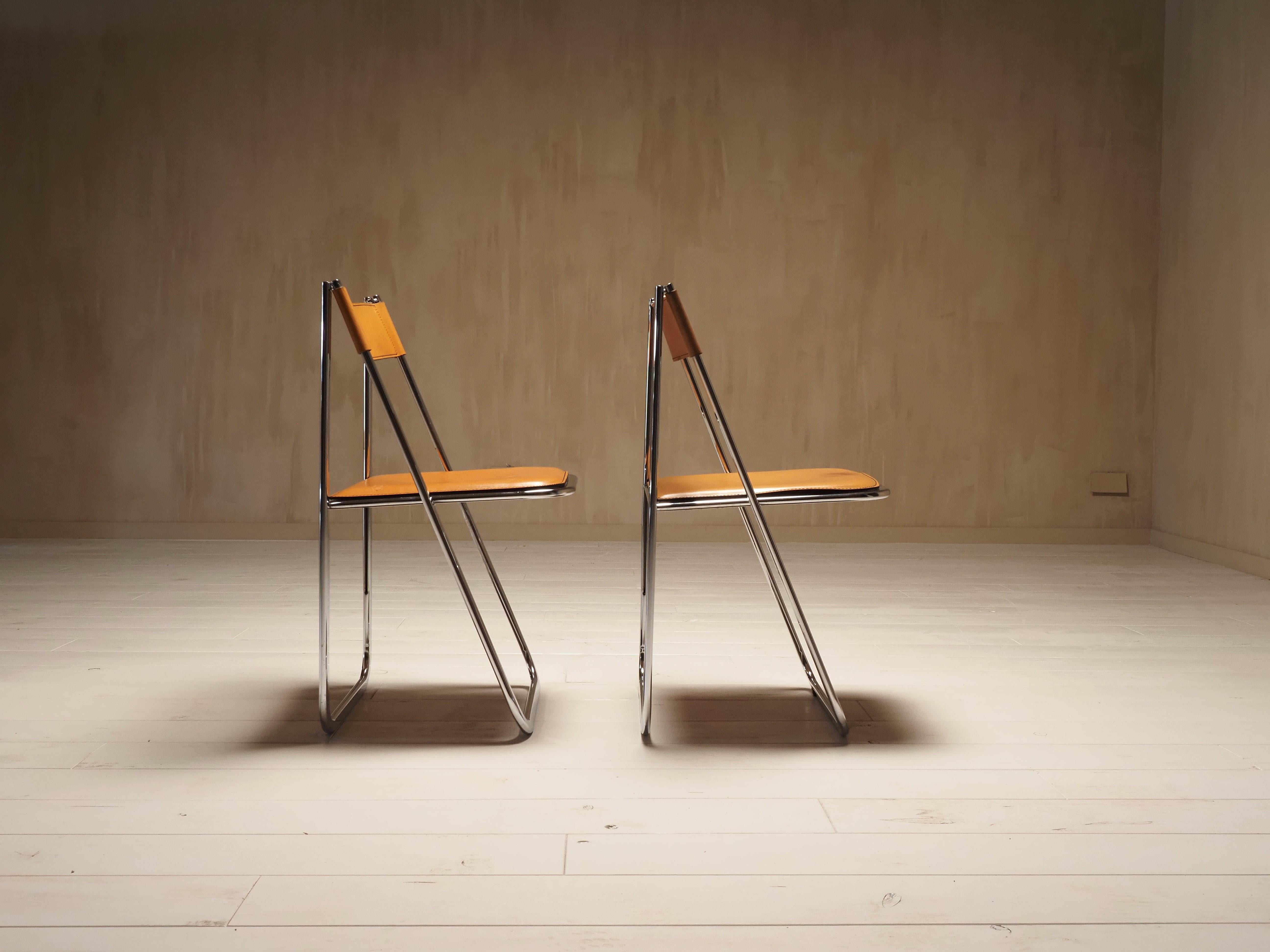 Pair of exceptionally rare postmodern folding chairs manufactured by Arrben. They feature chrome plated steel frames and cognac leather seats and back rests. Made in Italy in 1970s. Logo of the manufacturer is visible underneath the seats of the