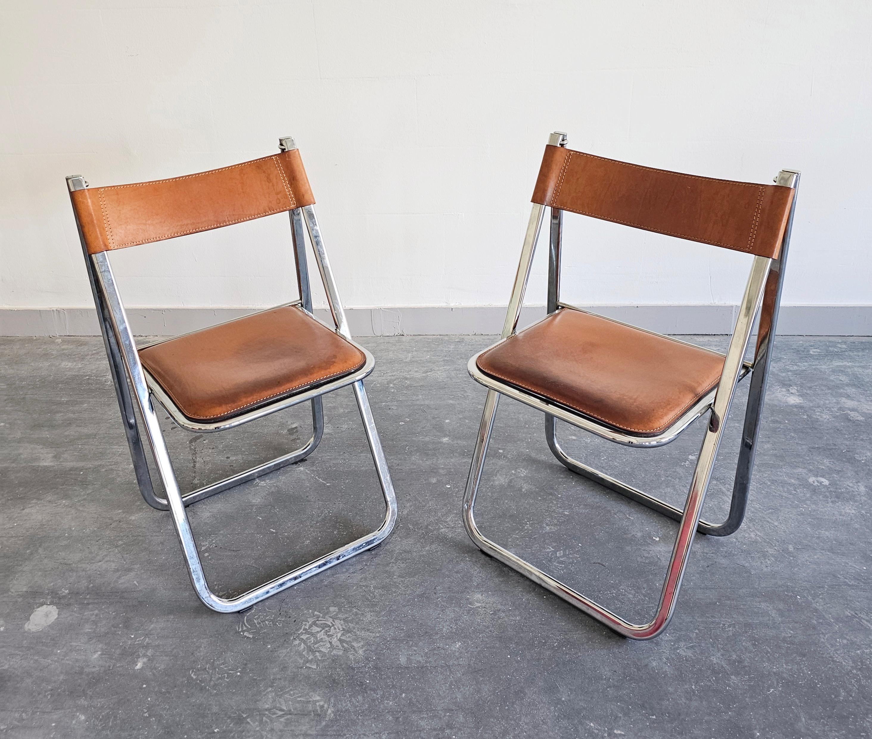 Vous trouverez dans cette annonce une paire de chaises pliantes postmodernes exceptionnellement rares fabriquées par Arrben. Ils sont dotés d'un cadre en acier chromé et d'une assise et d'un dossier en cuir cognac. Fabriqué en Italie dans les années