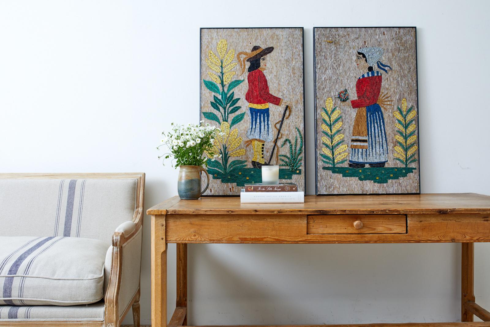 Charming pair of framed folk artworks or paintings made of mosaic tiles. Depicts a colonial-style man and woman among blooming vegetation. Beautifully crafted with vibrant colored tiles. Set in ebonized wood frames with minor losses as seen in