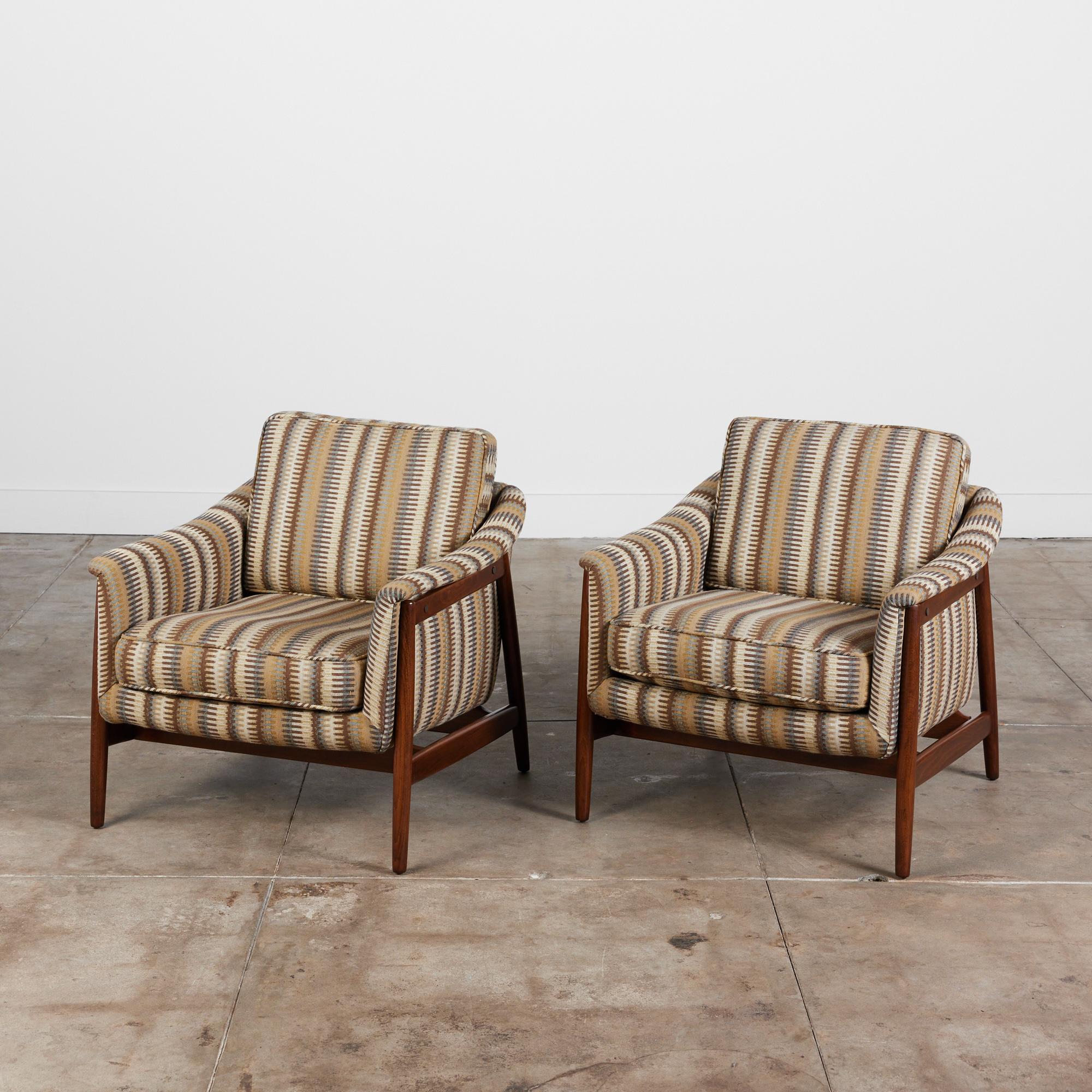 Pair of Folke Ohlsson designed lounge chairs for Dux, circa 1950s, Sweden. The chairs feature solid birch bases and upholstered seats in a geometric striped earth tone fabric.

Dimensions:
29