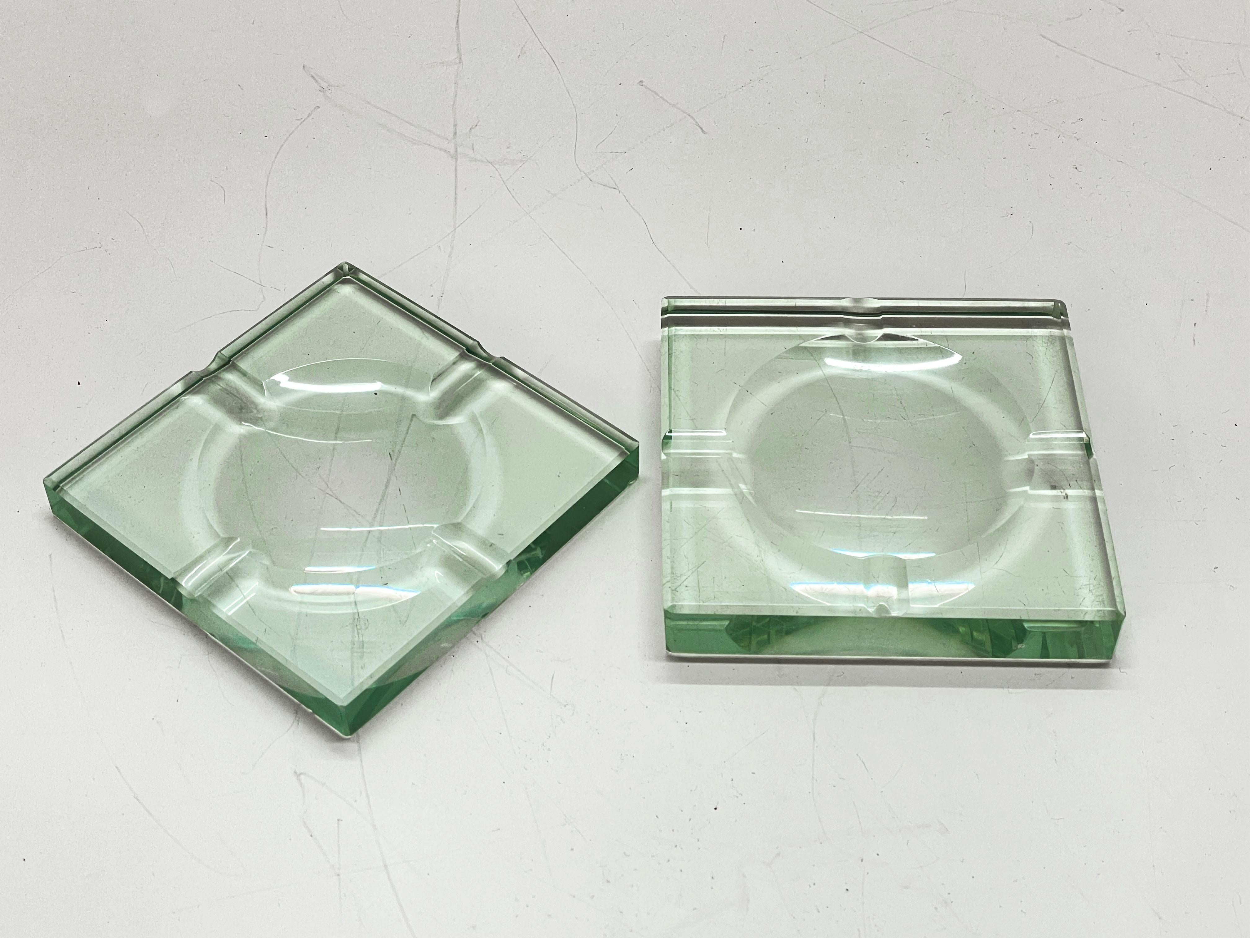 Deux incroyables cendriers carrés en verre vert du milieu du siècle dernier. Ces magnifiques pièces ont été produites par Fontana Arte en Italie dans les années 1960.

Les articles sont en cristal carré vert avec une sculpture géométrique, le