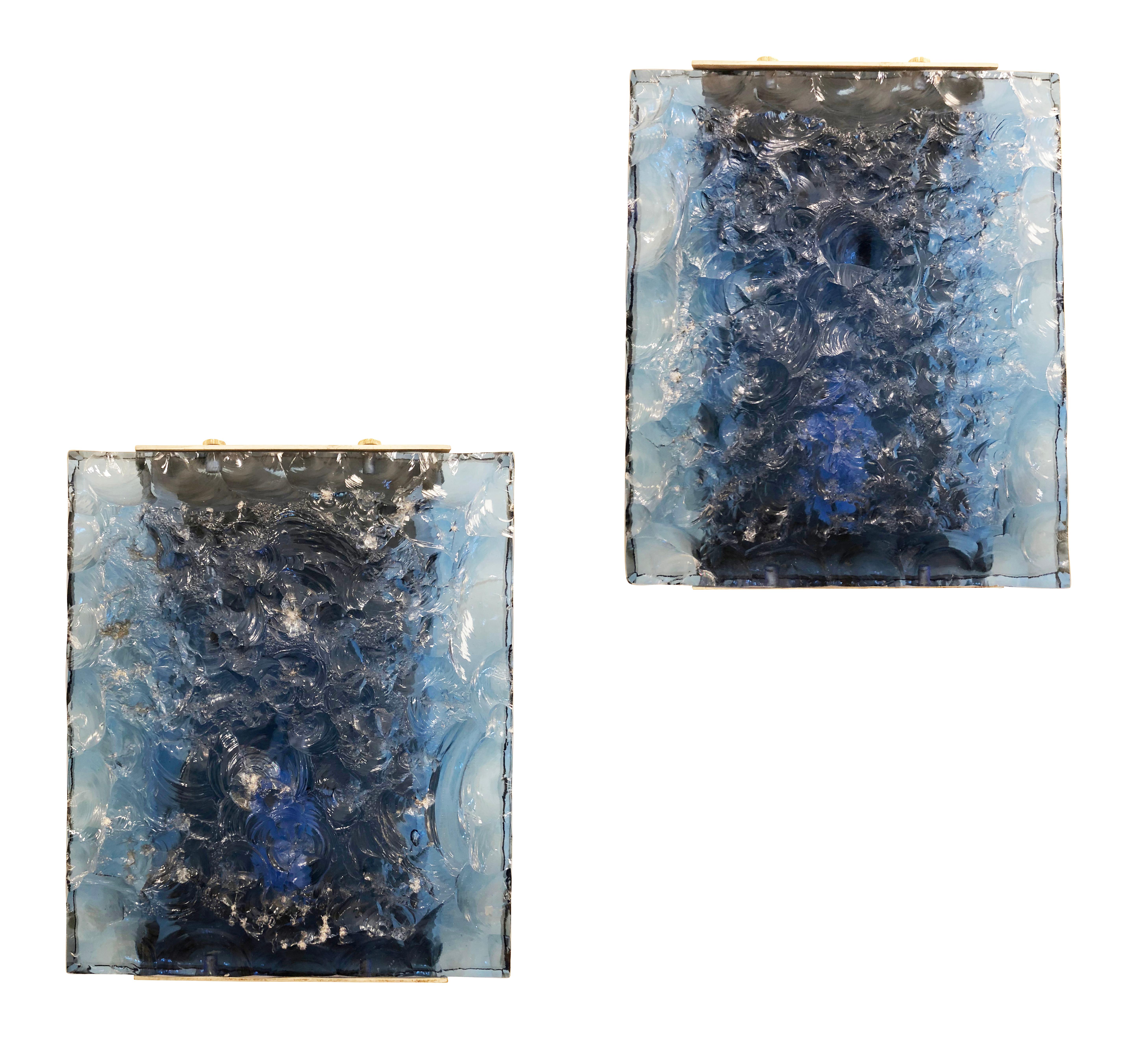 Pair of Fontana Arte sconces designed by Max Ingrand in the 1950s featuring hand chiseled glass shades. The dark blue glass makes this pair especially rare as it was a custom commission. The stock model was typically done with a green glass. The