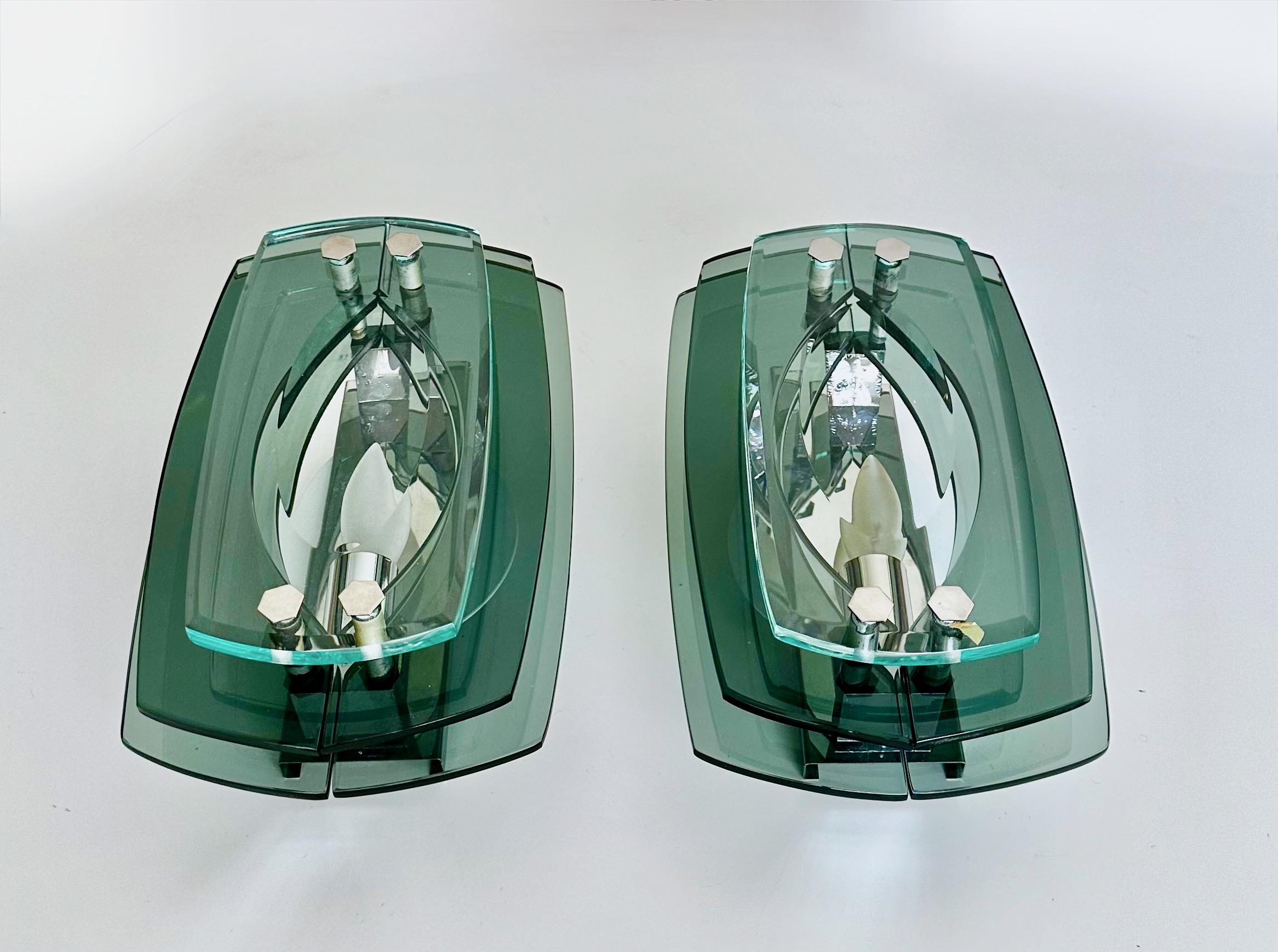 Pair of modern mid century Italian made sconces in the style of Fontana Arte, three layers of translucent shades of greenish color glass with chrome-plated fittings and backplate. Takes one candelabra E12 size bulb, newly wired. The fixture hangs on