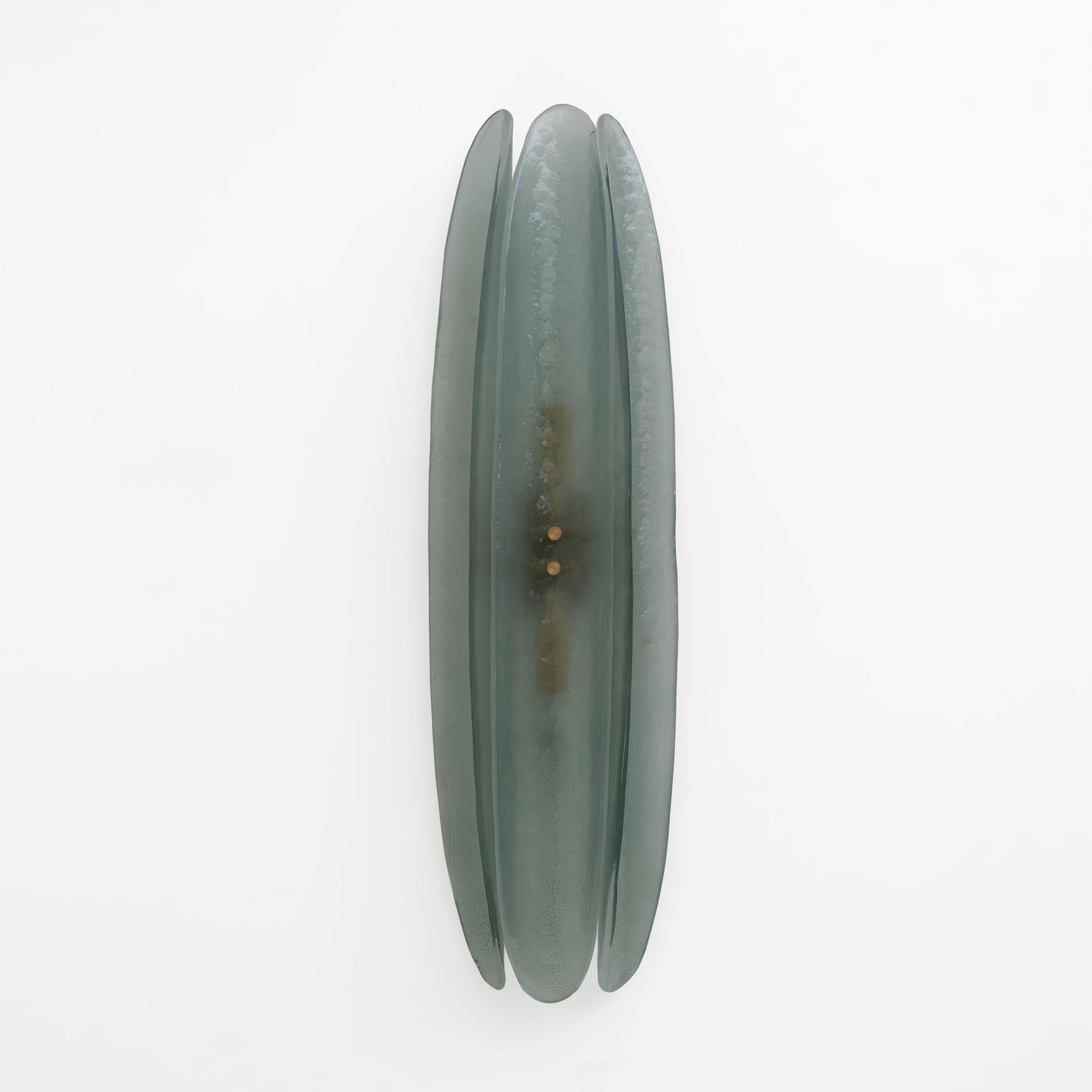 Wall sconces composed of three organic elements in curved satin Murano glass in the shape of a leaf in the color aquamarine in the style of Fontana Arte. The elongated parts are concave and embrace the brass structure in a semicircular shape that