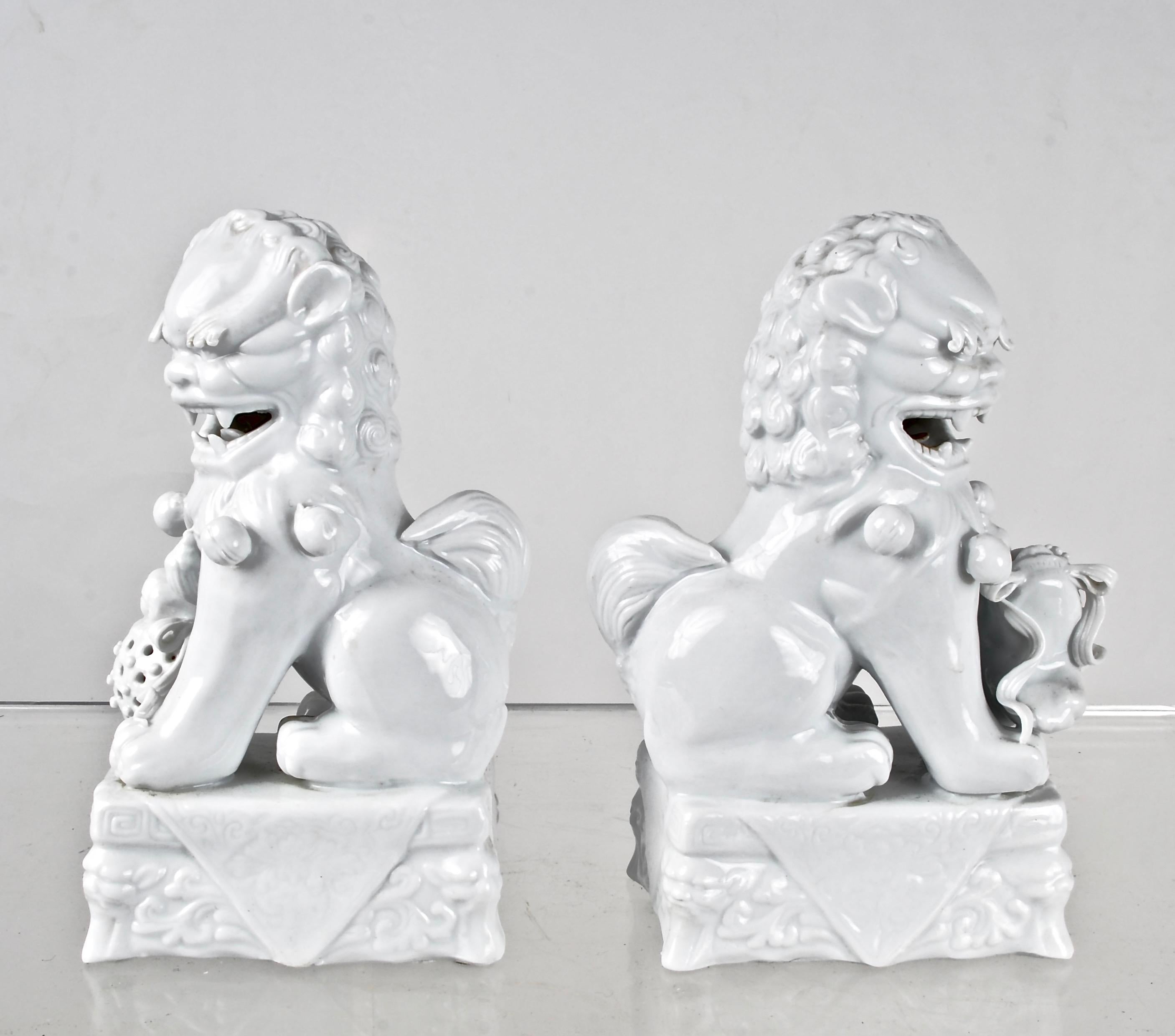 A wonderfully detailed pair with fine modeling and beautiful glaze over true white. A true pair, with one figure holding a cat fish complete with whiskers and the other a cricket cage. Great attention to detail and traditional whimsical expressions.