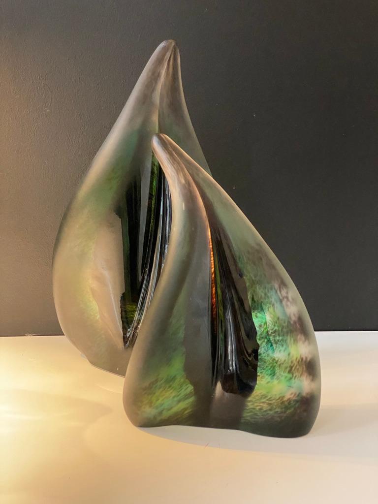 A pair of unique handmade and hot formed green glass sculpture created using 'sommerso' muranese glass making technique. Massive and freeform, these pieces have an artistic posture. These two have layers of natural colors and have a frosty finish on