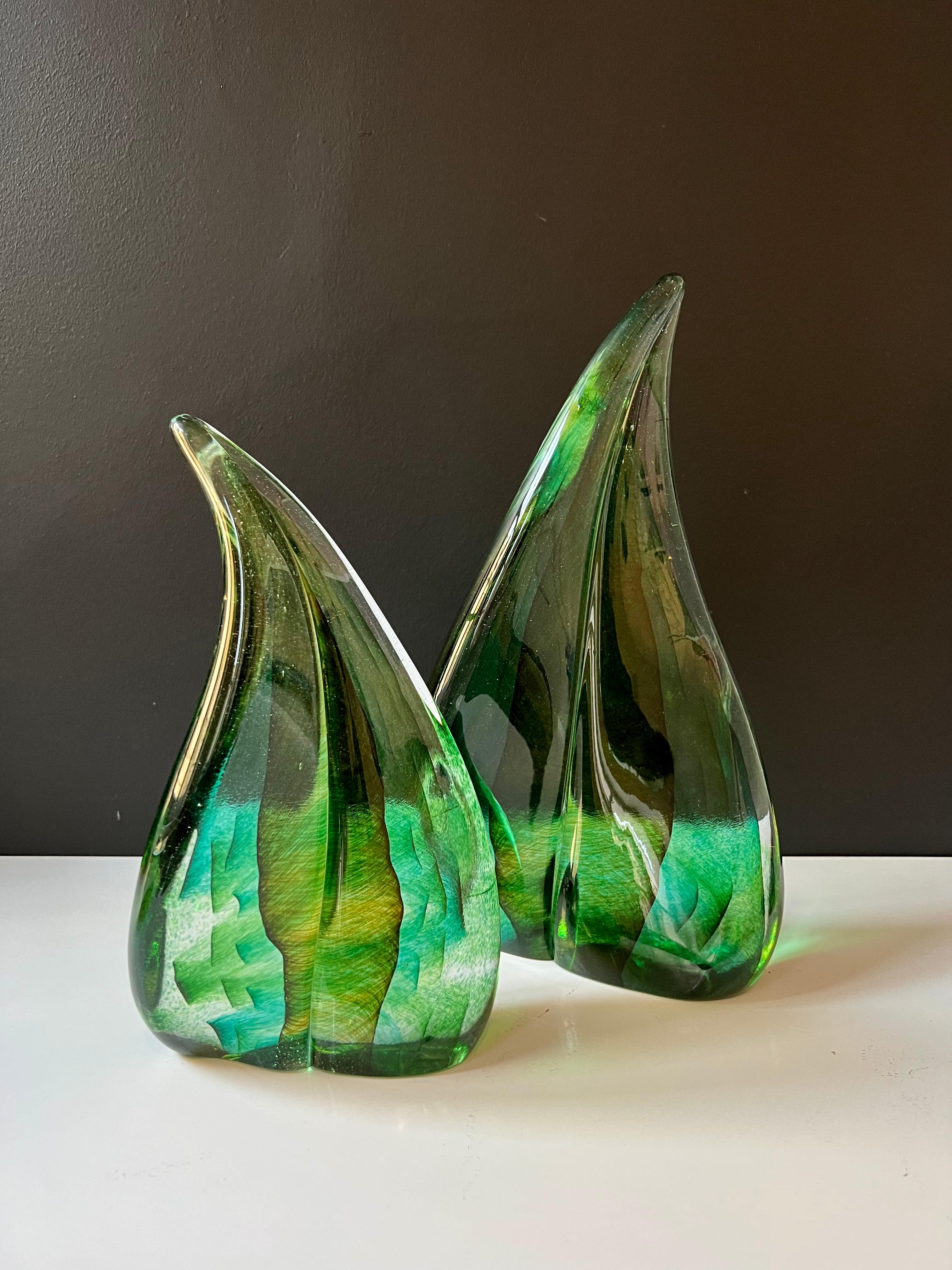 Laissez-vous séduire par la beauté de notre paire de sculptures en verre vert fabriquées à la main, chacune étant méticuleusement formée à l'aide de la technique de verrerie muranaise 