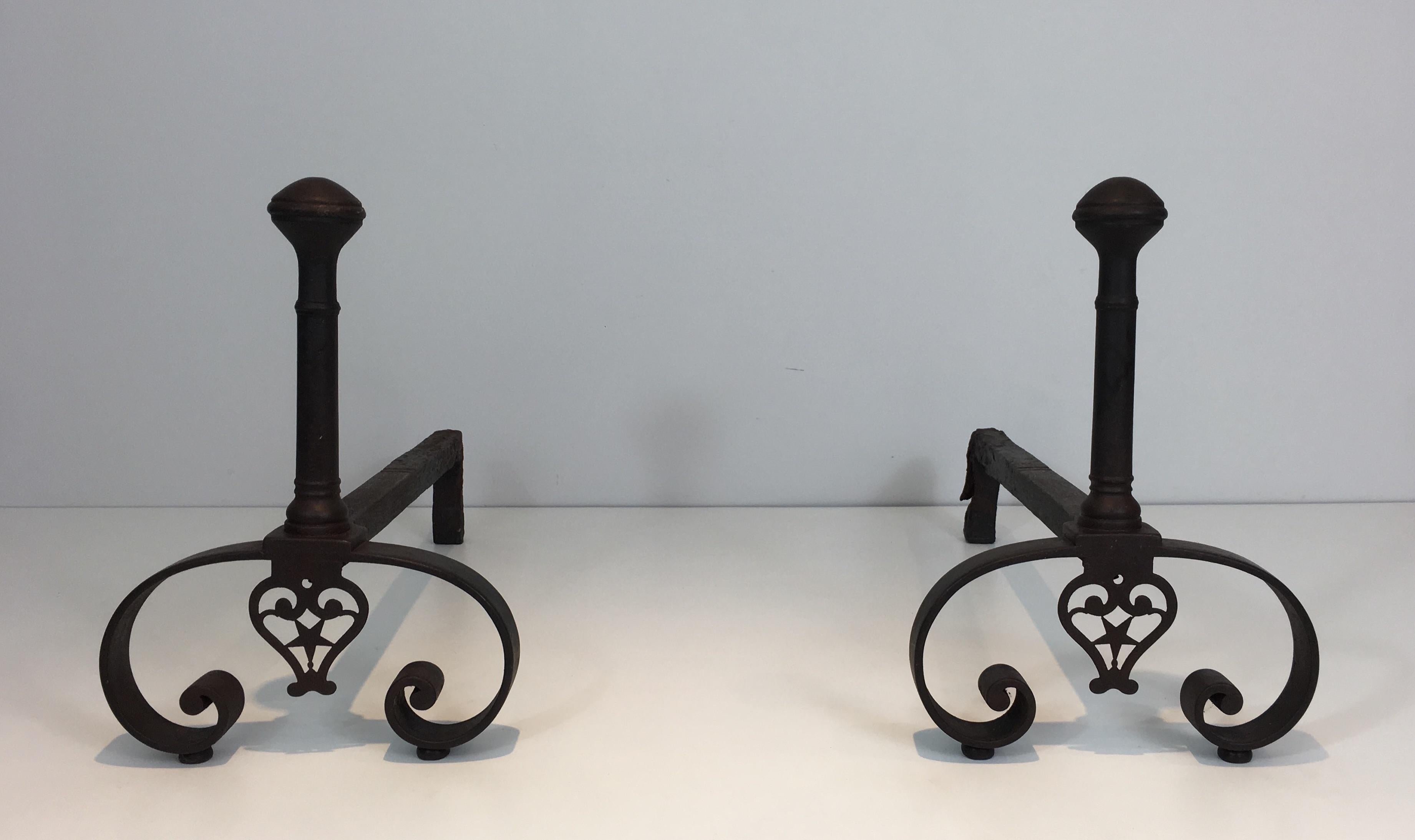 This pair of forged andirons were made in France in 18th century, in the gothic style. They have a very nice color of time. The decoration on the bottom with the star is very fine and nice. They are heavy, made of a good quality and have timeless