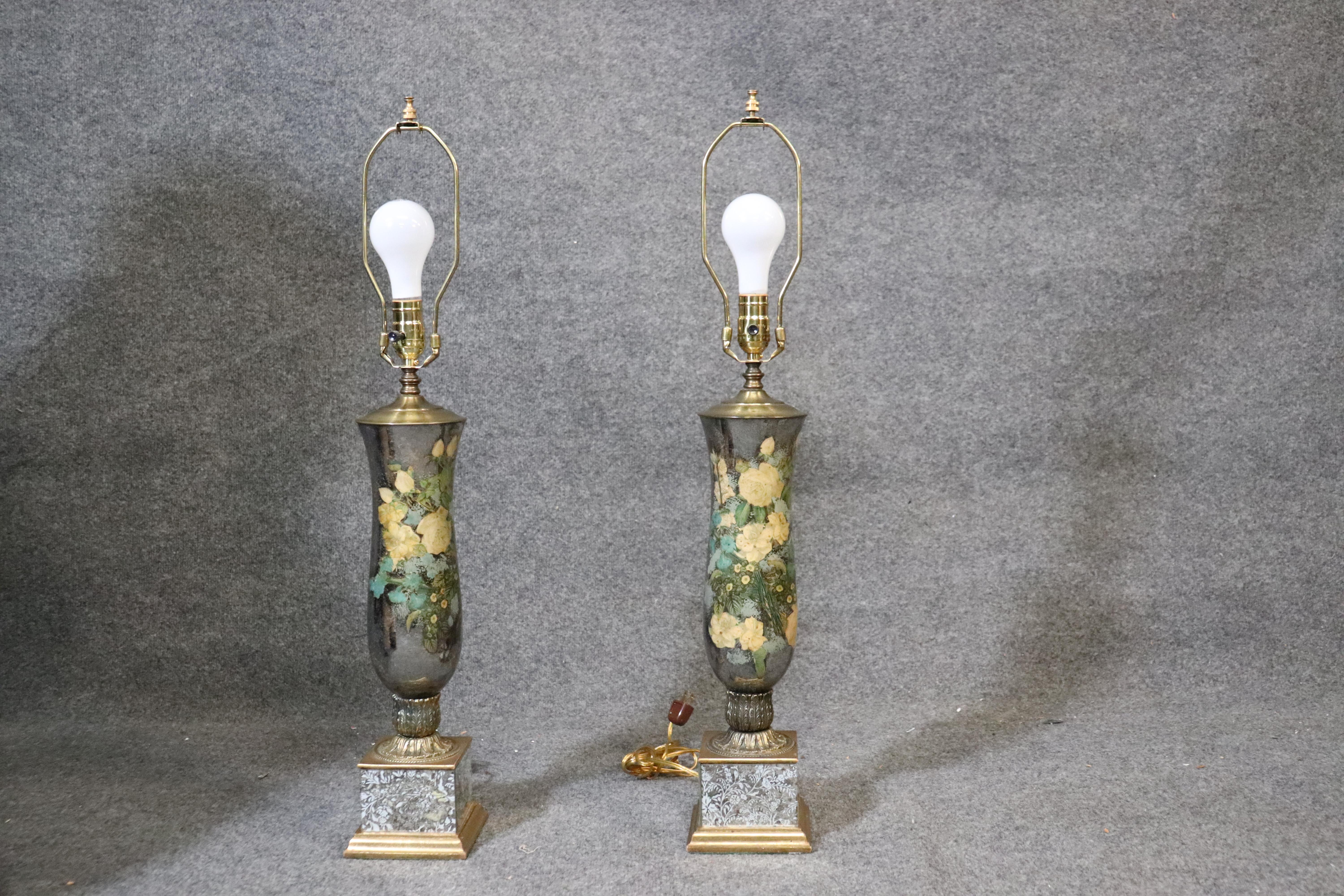 This is a rare pair of beautiful Fornasetti style silver leaf gilded paint decorated lamps. The detail of the bases in the bronze casting is extraordinary. The condition of the églomisé is very, very good with no apparent losses. The lamps date to