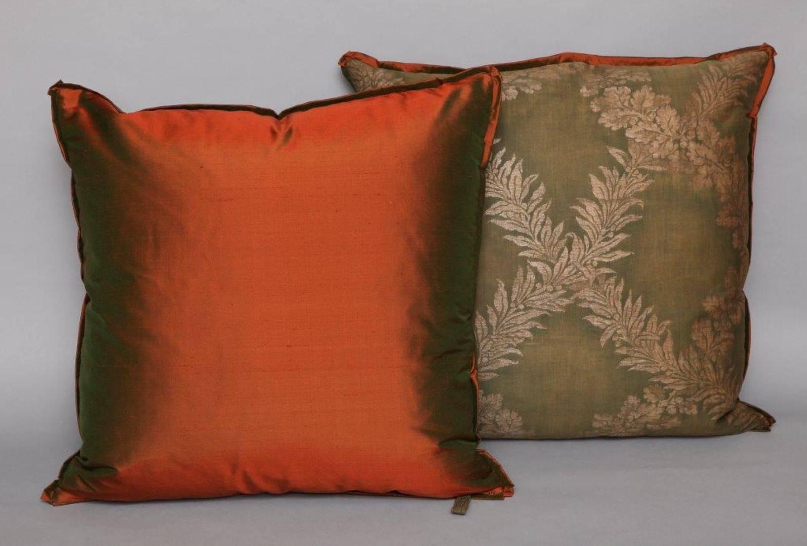 A pair of Fortuny fabric cushions in the Crosoni pattern, green ground with silk bias edging and red taffeta backing material, the pattern, an 18th century French Empire design with formal motif. Newly made using vintage Fortuny fabric, discontinued