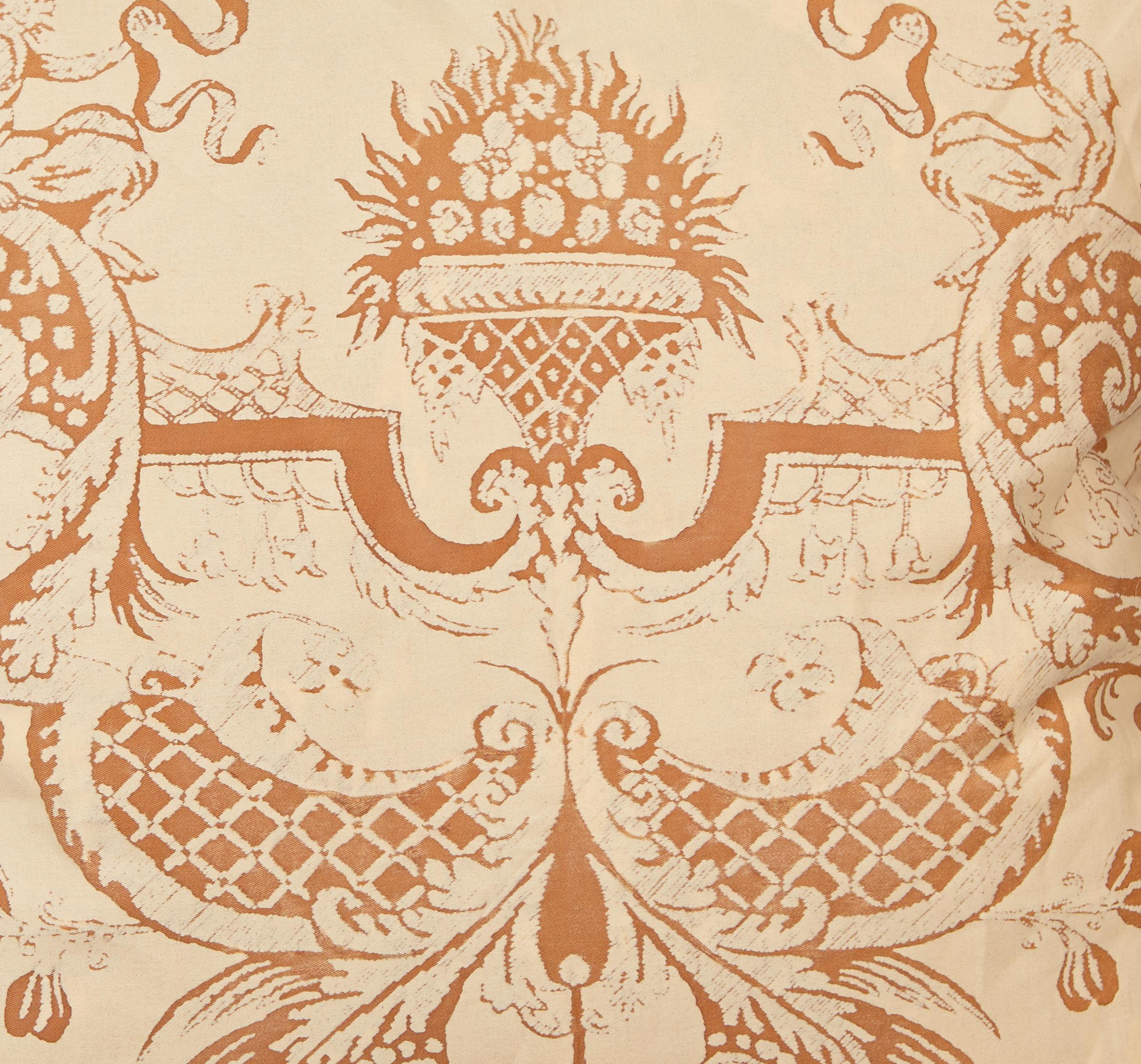 A pair of Fortuny fabric cushions in the Mazzarino print, rust and tan colorway with striped bias edging and tan backing. The Mazzarino the pattern is a 17th century French design named after Cardinal Mazarin at the Court of Louis XIII and Louis