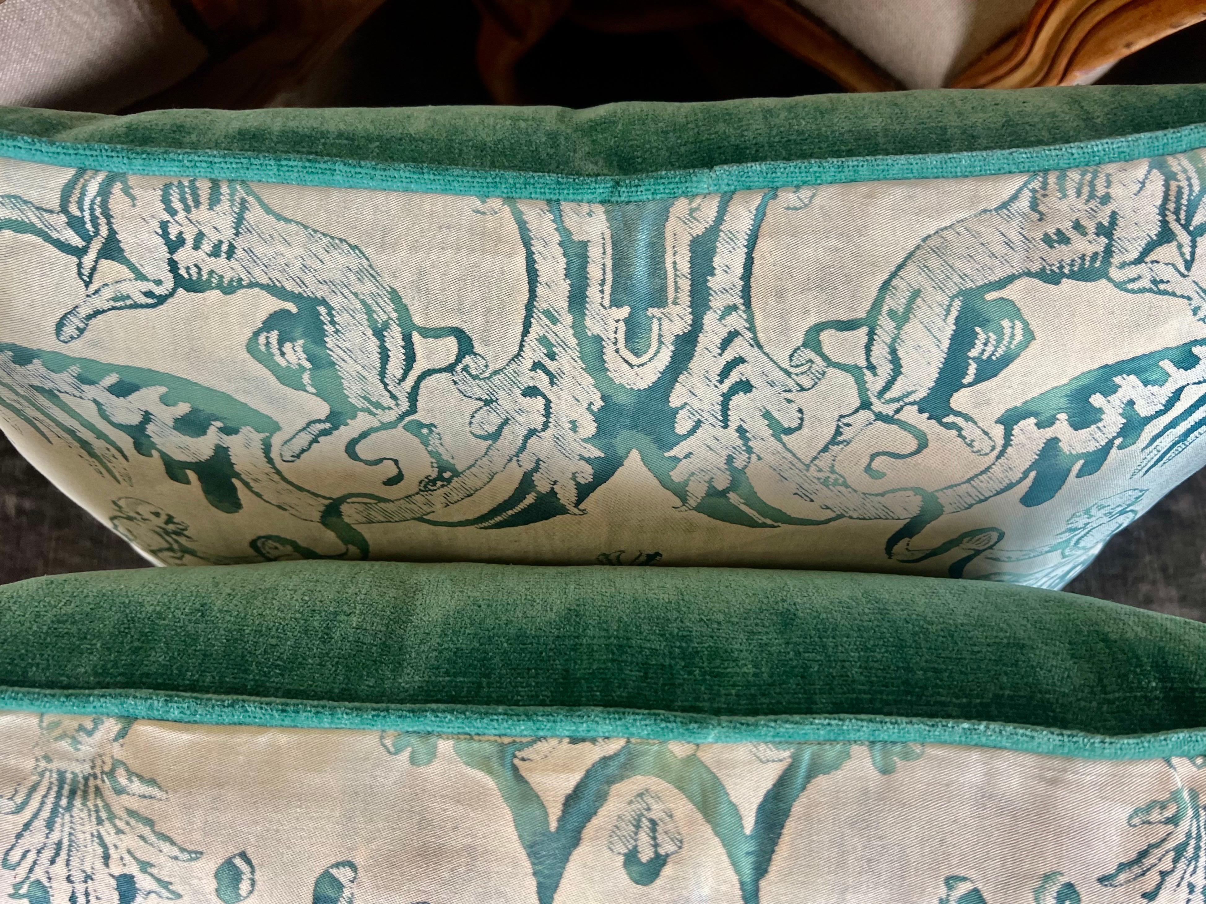 A pair of custom Fortuny textile pillows adorned with the Manzianno pattern in colors of peacock and beige.  The intricate Italian design is complemented by velvet backs in the same peacock coloration and finished with self cord detail, and down