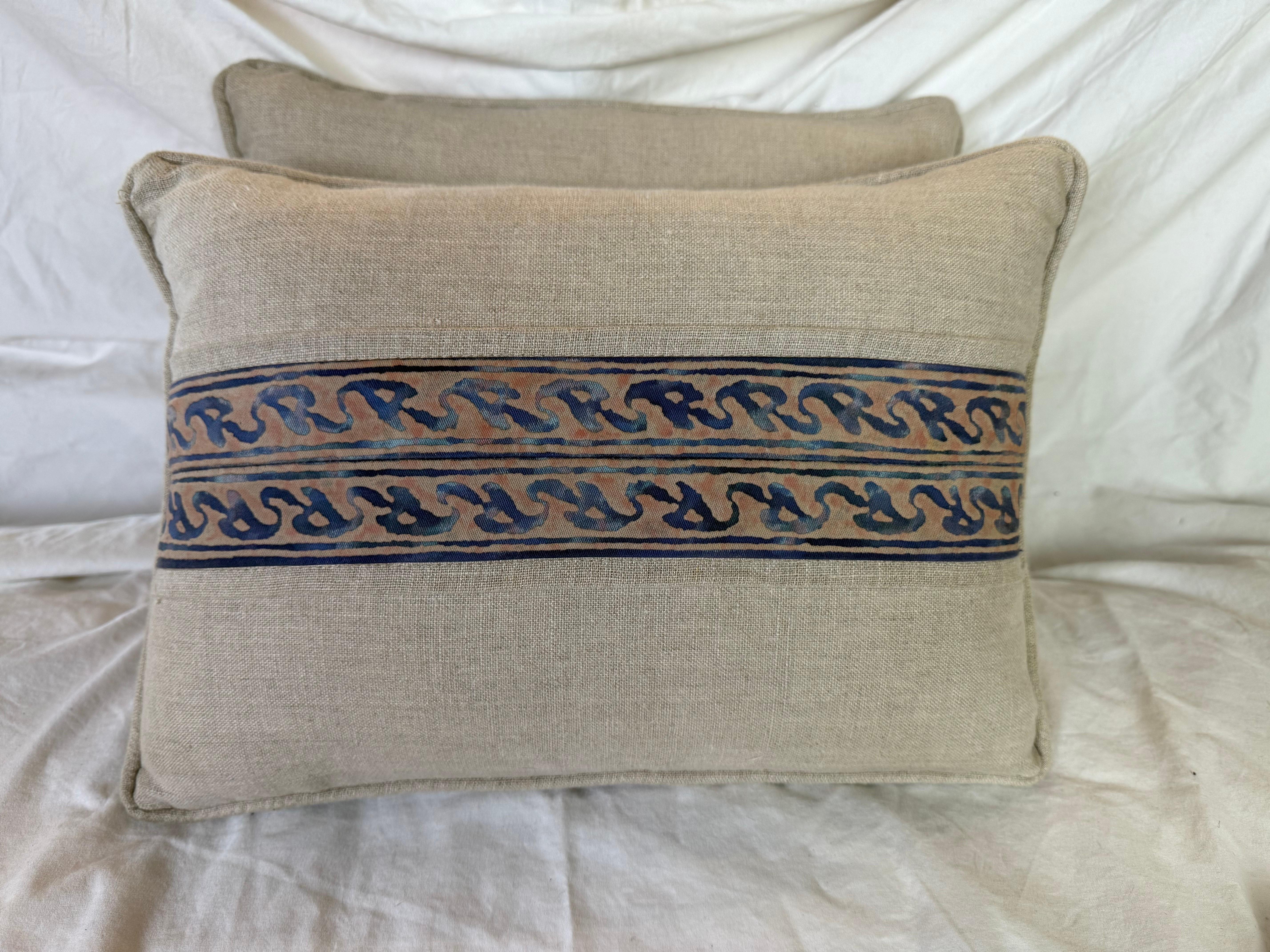These stylish pillows blend classic elegance with rustic charm through a combination of Fortuny textile and Belgian linen. The front of each pillow features a central panel of Fortuny fabric in a muted palette of indigo, earthy taupe, and soft rust