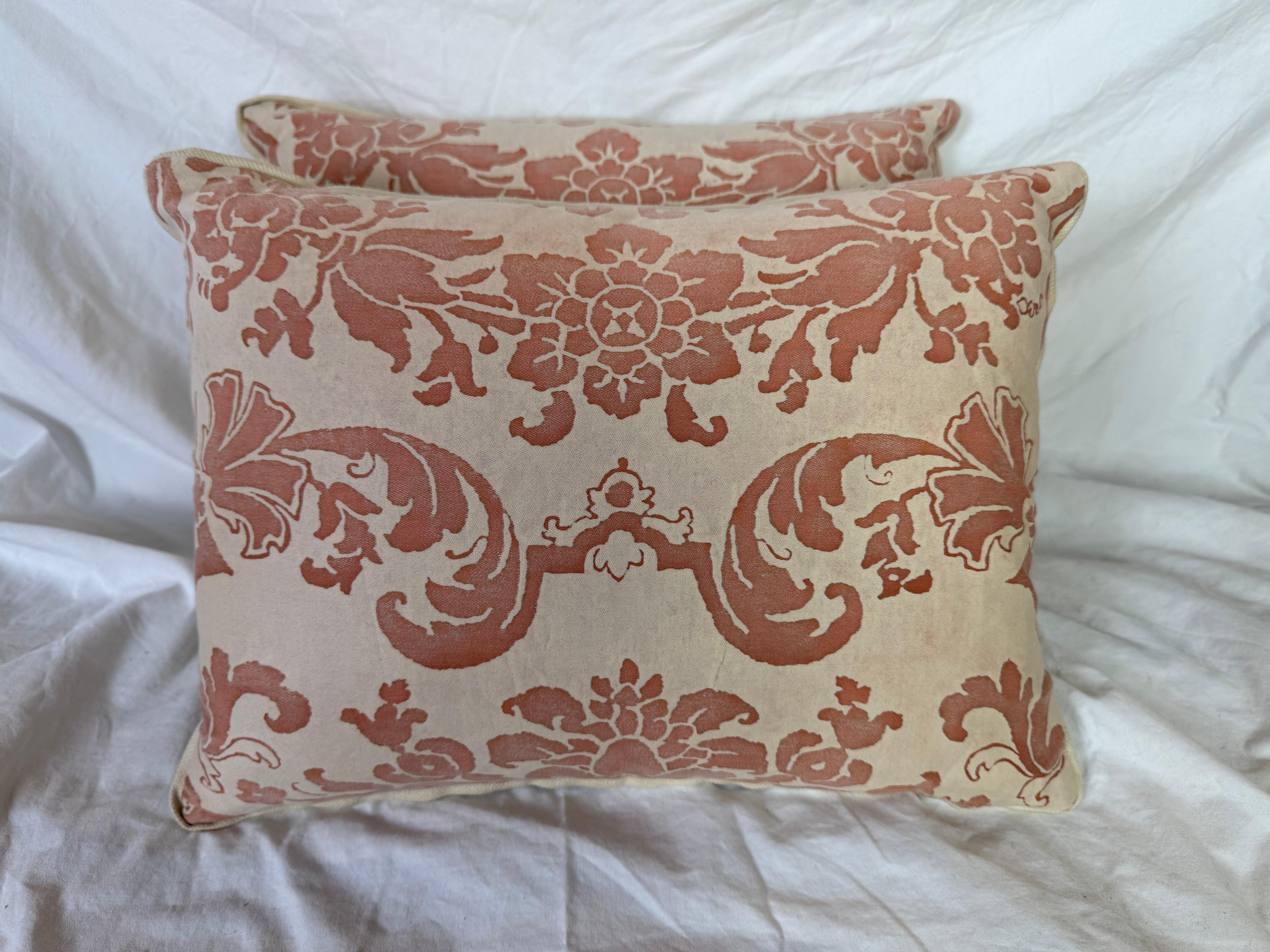 Questi cuscini Fortuny presentano un elegante motivo floreale ispirato alla damascena in una calda tonalità di terracotta su un morbido sfondo beige neutro. Gli intricati motivi floreali e di fogliame sono caratteristici degli intramontabili disegni