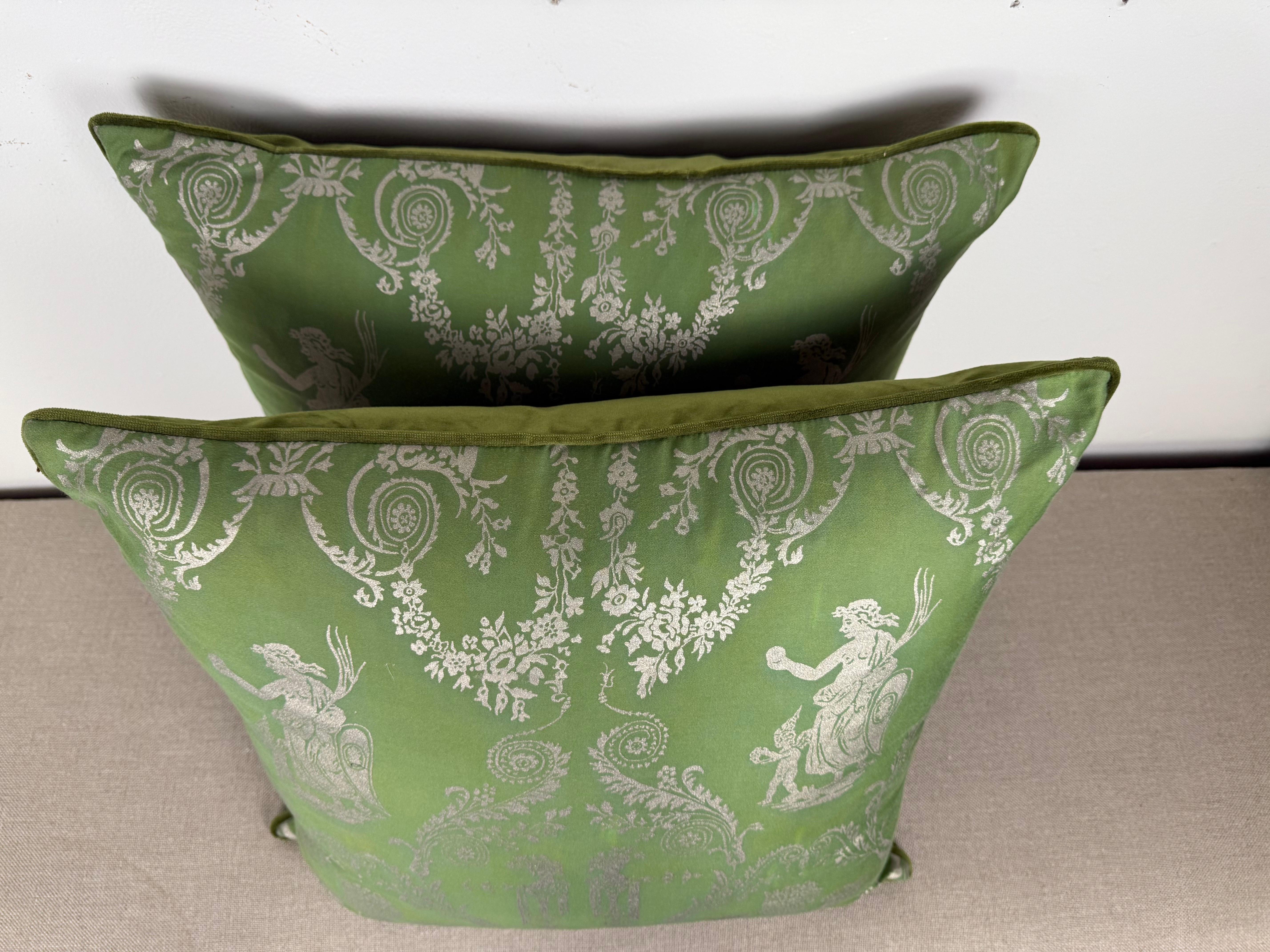 Questi eleganti cuscini sono caratterizzati da autentici frontali in tessuto di Fortuny in un morbido verde ornato da intricati motivi classici stampati in una colorazione argentata. Il modello presenta figure neoclassiche, fiori e volute