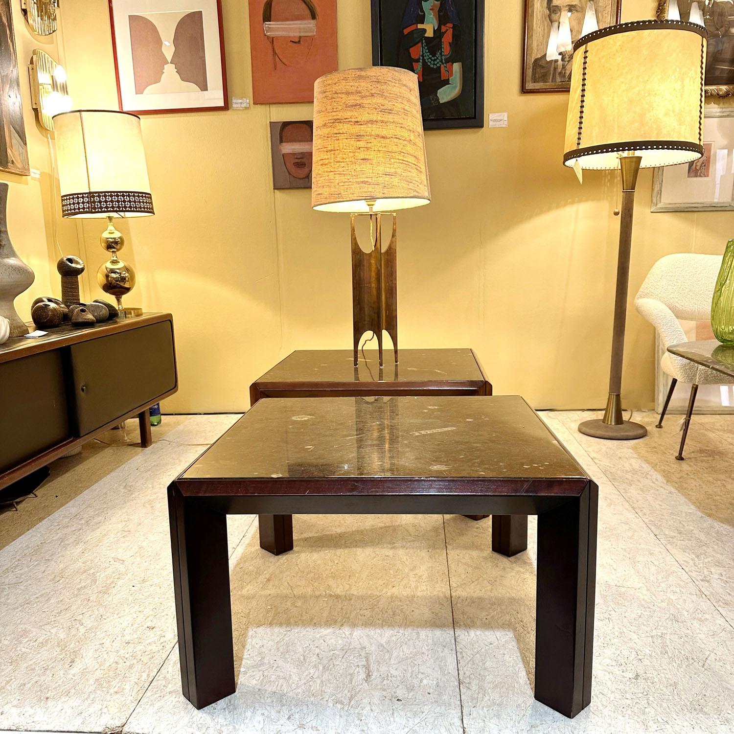 Pair of square coffee tables are made of solid wooden frames with chamfered edges that hold fossilized stone tops. These fossils tell the history of 350 million years and are the ancient ancestors of ammonites and squid, embedded in the stone plated