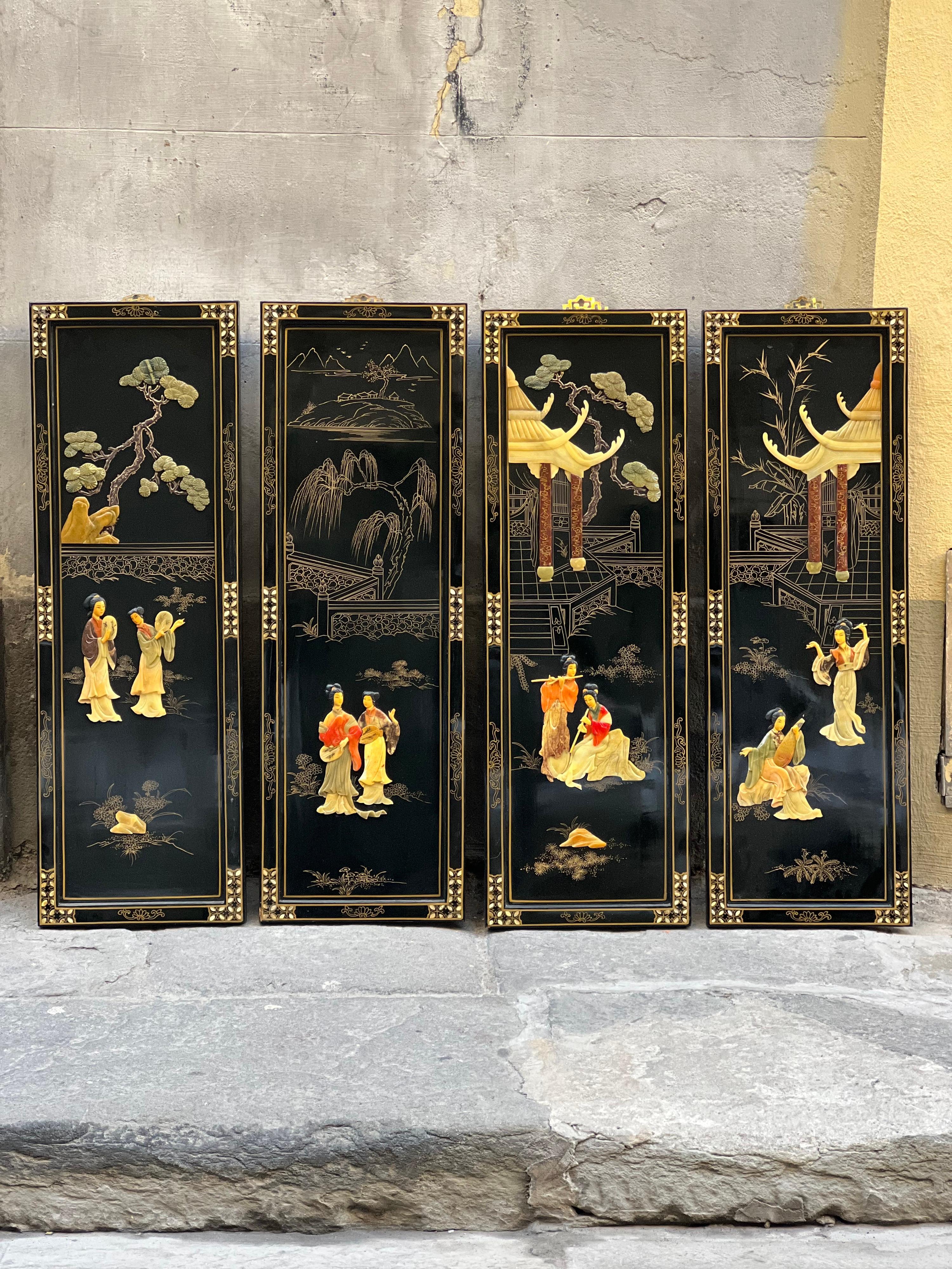 Pair of four antique Chinoserie Lacquered black wood wall panels
Decorative panels inlaid with mother of pearl, jade and hardstone 
with Chinese scenes highlighted in gold.
Ebonised frames with stylised gold and mother of pearl decoration
Each panel